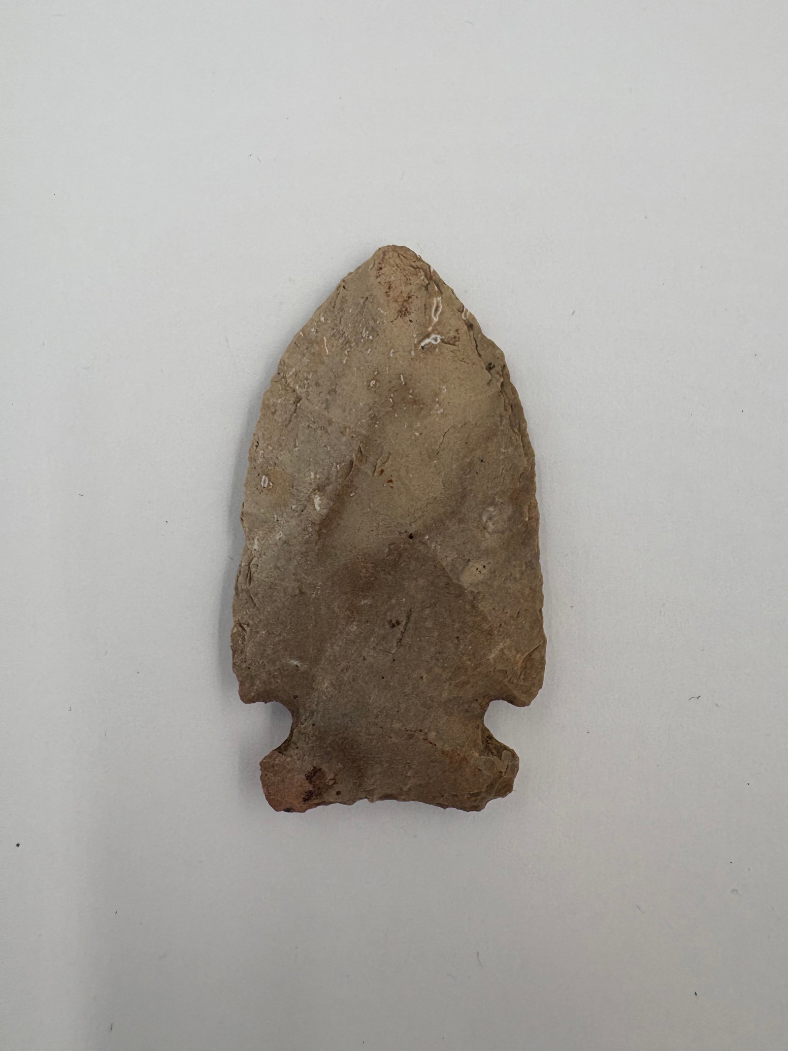 Cache River Point - 2 1/4in: Cache River-style projectile point measuring 2 1/4 inches. Knapped from fine-grained tan to brown stone with visible flake scars and small cortex remnants. Broad leaf-shaped blade tapers to a notched
