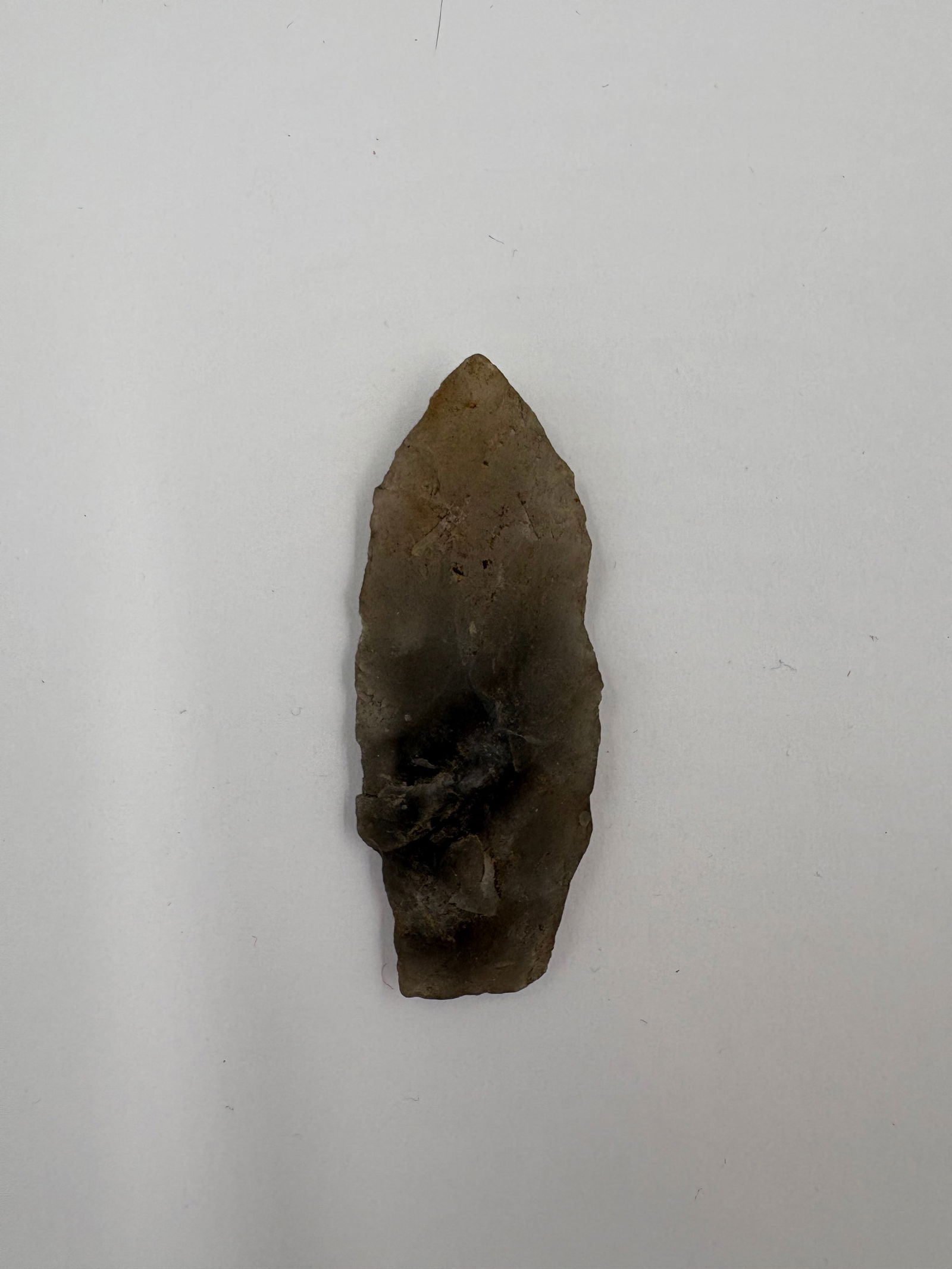 Novaculite Adena Point - 2 1/4in: Adena-style point crafted from translucent brown-gray novaculite, 2 1/4 inches in length. Narrow lanceolate profile with bifacial flaking and fine pressure-flake edge work. Surface exhibits smoky