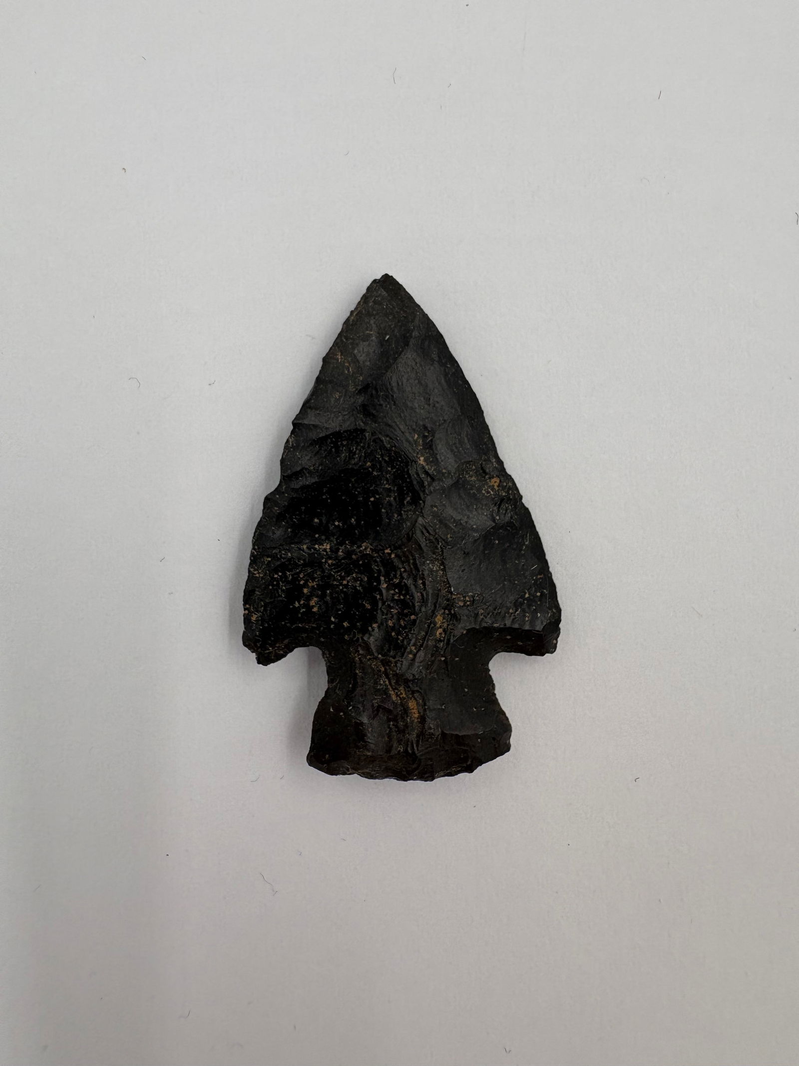 Hardin, Excello chert: Hardin point crafted from glossy black Excello chert with a triangular, bifacially flaked blade. Shouldered stem and distinct basal notches lead to a slightly expanded base with pronounced flake scars