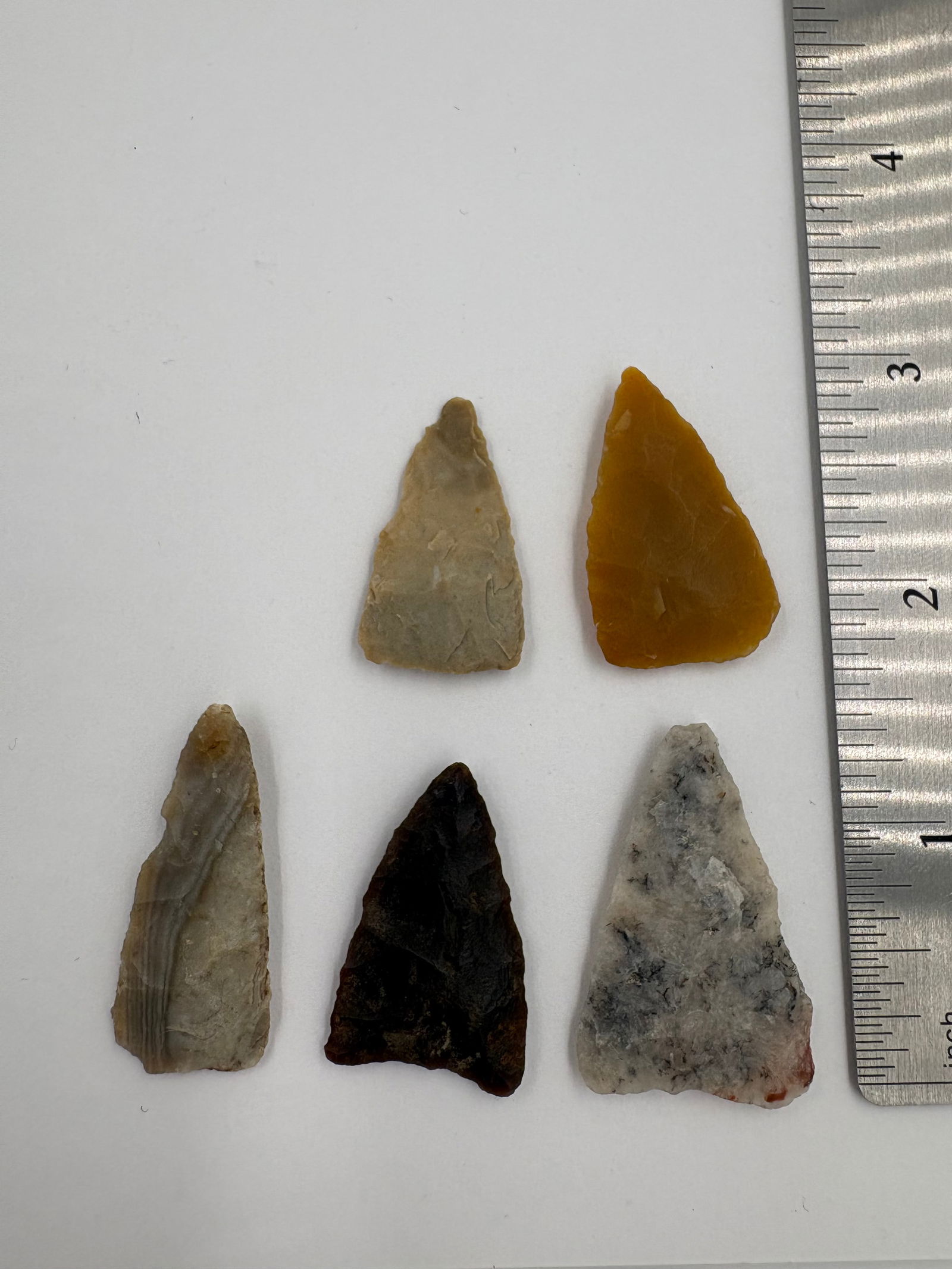 Group of Western Agate Points: Assortment of Western agate projectile points with triangular to lanceolate shapes and flaked, bifacial workmanship. Coloration includes golden-yellow, brown, gray, and mottled white with banding and
