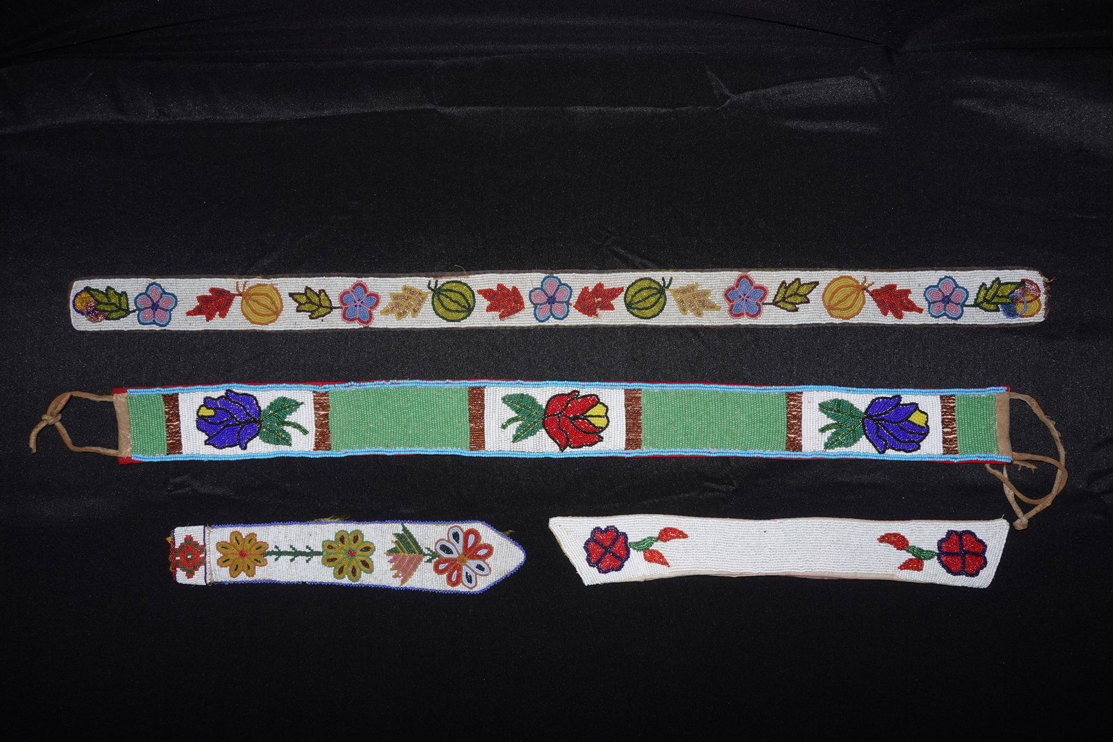 Plateau beaded belt, Collar, and Tie: Beaded belt, collar and tie executed in Plateau beadwork with colorful glass seed beads forming floral and leaf motifs on a white beaded ground. Design elements include green rectangular panels
