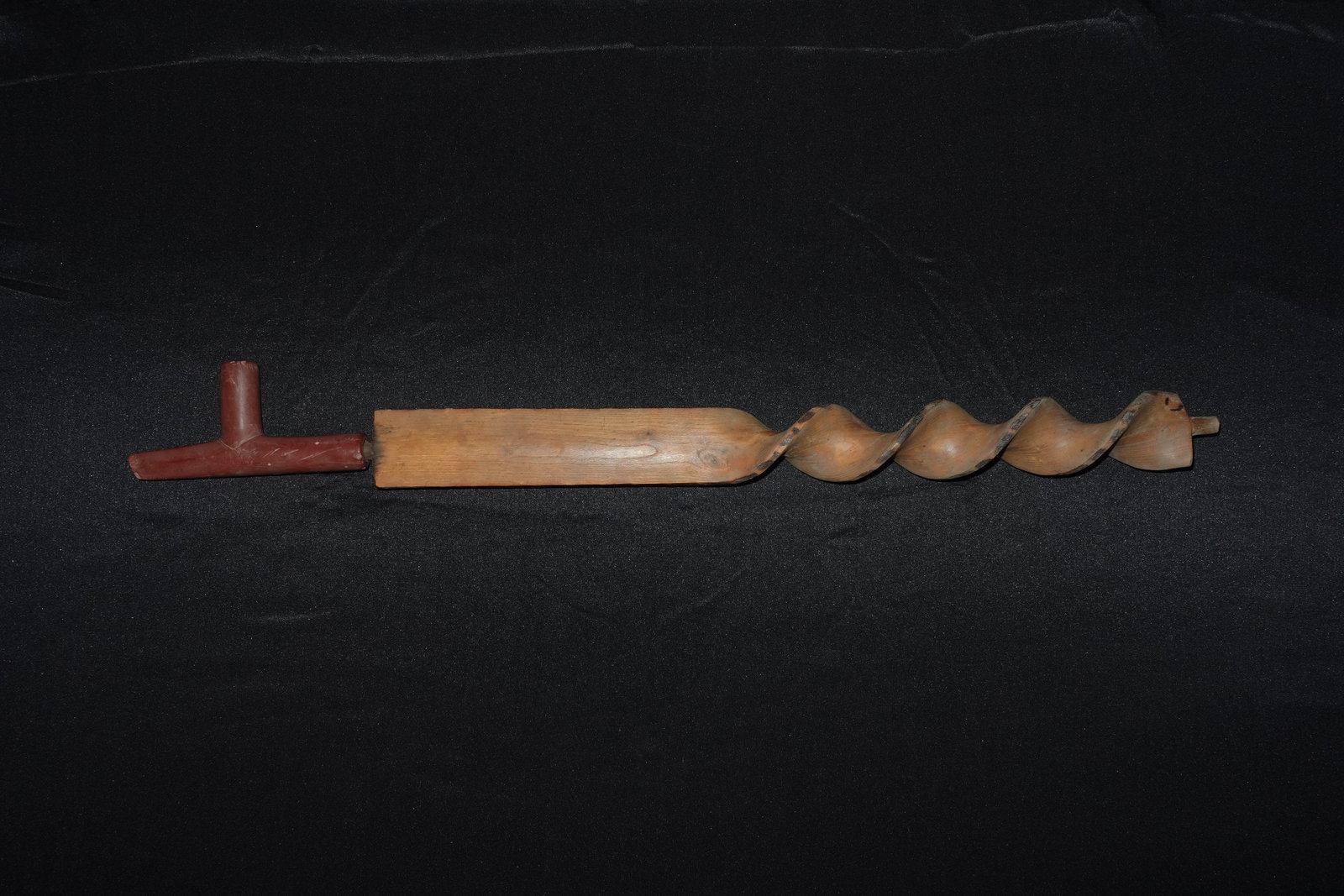 Sioux Carved/Twisted Pipe and stem: Carved wooden pipe featuring a long spiral-twisted bowl with pronounced fluted ridges and a rectangular shank. A T-shaped catlinite mouthpiece in reddish-brown joins the wooden stem. The wood