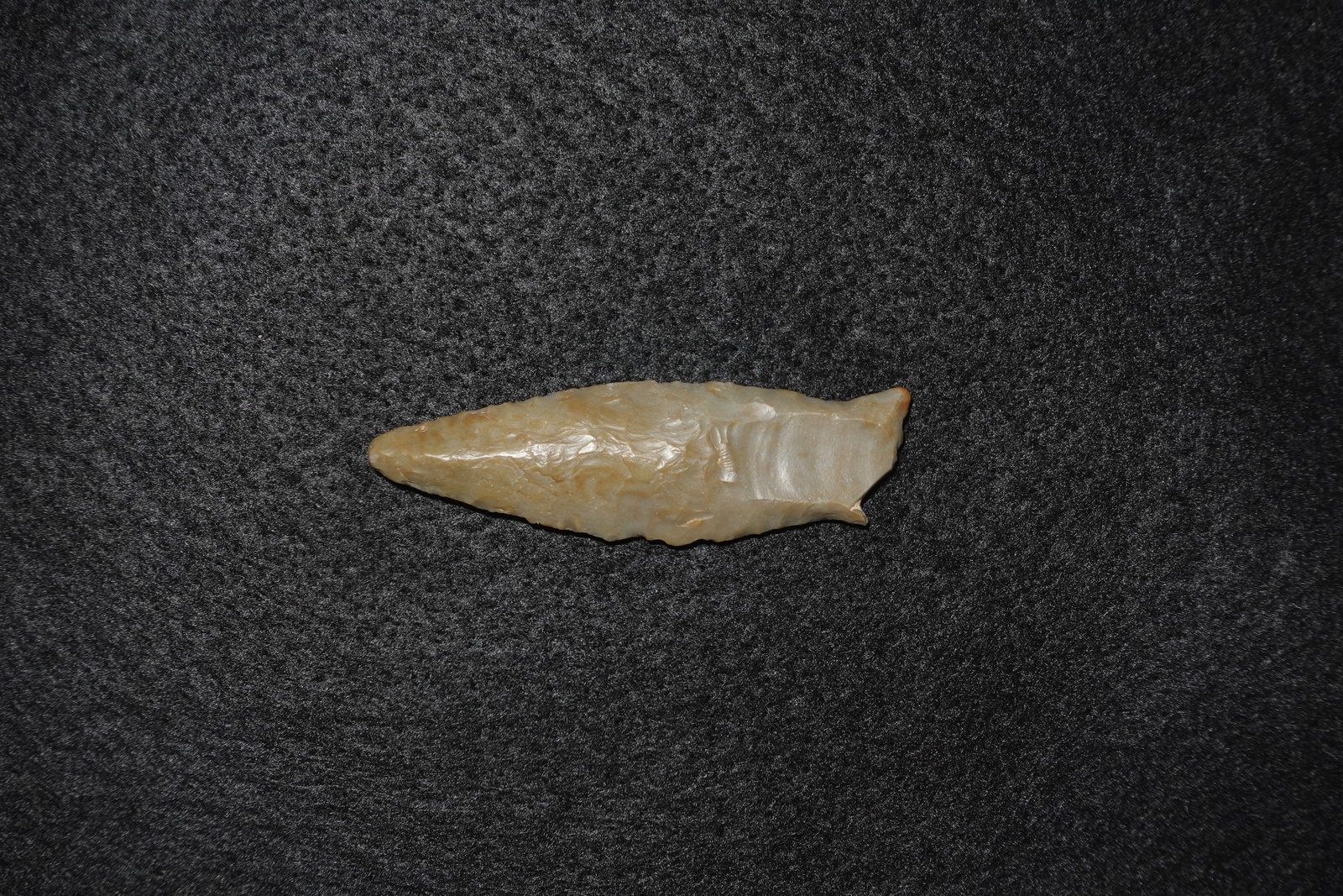 Cumberland: Leaf-shaped flaked chert projectile point with bifacial pressure flaking and a narrow tapered tip. Translucent gray-cream stone displays light brown edge staining, finely reworked margins and a