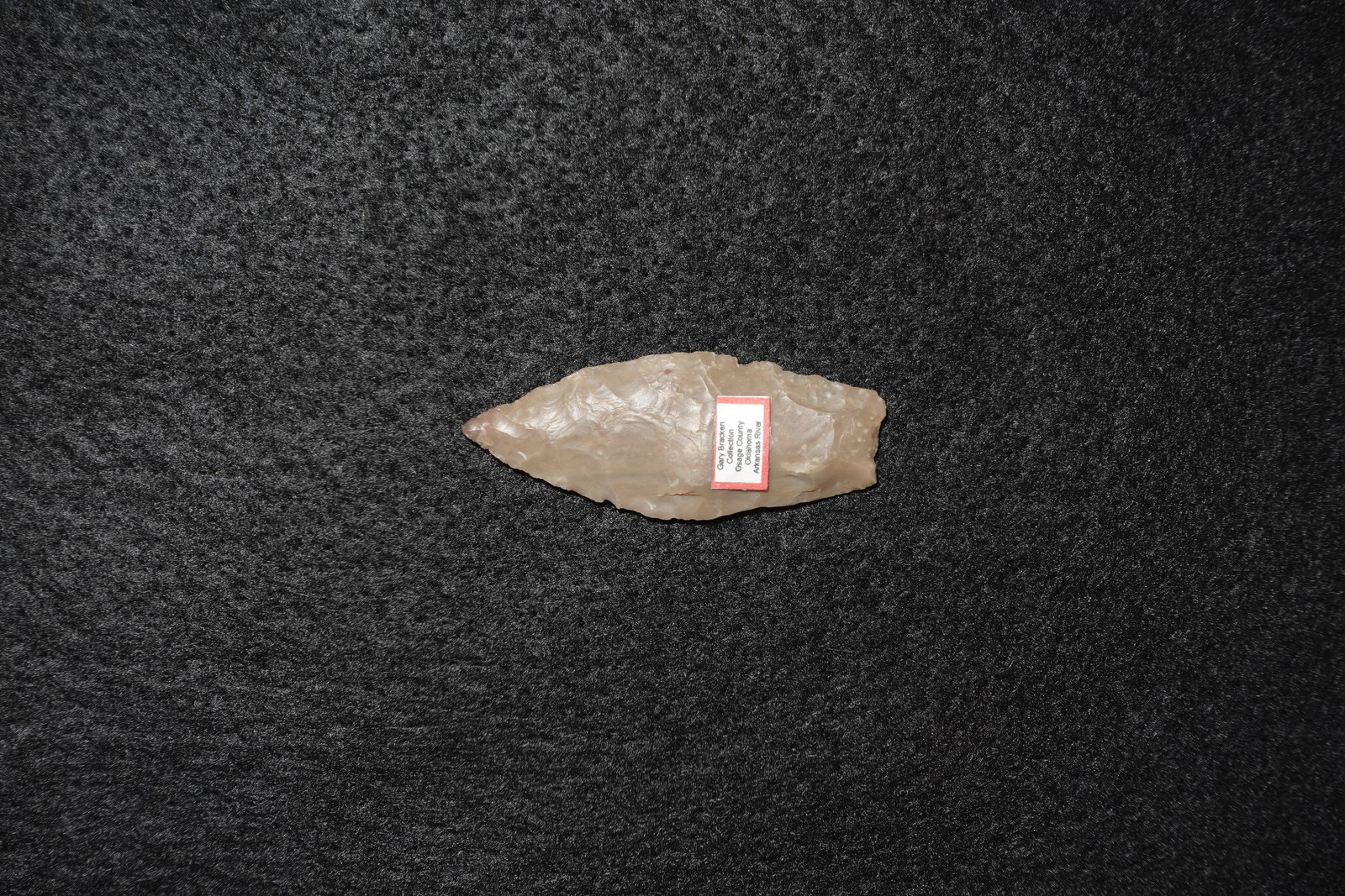 Agate Basin: Elongated lanceolate Agate Basin-style projectile point fashioned from translucent pale tan to pink chalcedony. Bifacially flaked with overlapping pressure flake scars across both faces and a sharply