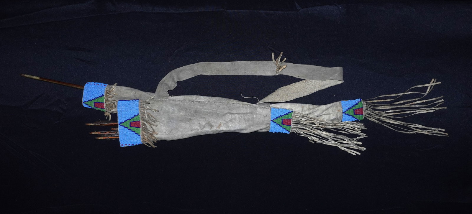 Sioux Beaded Box and Quiver Set: Pale gray leather quiver with long shoulder strap and extended fringe, trimmed at the mouth and lower opening with light-blue glass seed bead cuffs featuring green triangular panels and red center acc