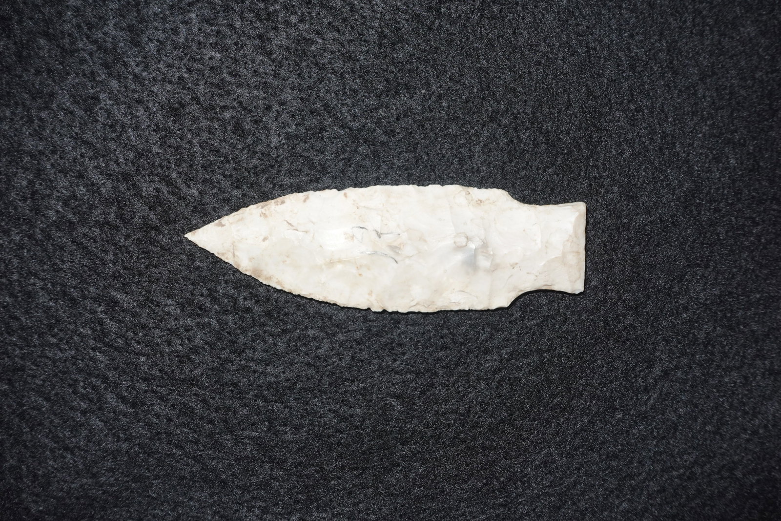 Stueben: Extra-fine, thin white chert biface with a pronounced needle-tip point and delicate pressure-flaked edges. Leaf-shaped blade tapers to a defined basal haft area and shows symmetrical flake scar