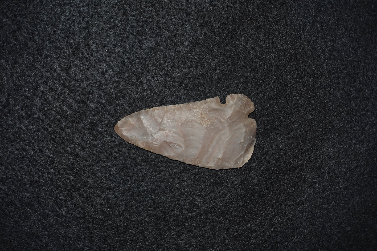 Corner Tang Knife: Flaked chert knife with a distinct corner tang base and pronounced bifacial flaking along the blade. Translucent tan-to-brown stone displays overlapping pressure-flake scars, subtle banding, and a sha