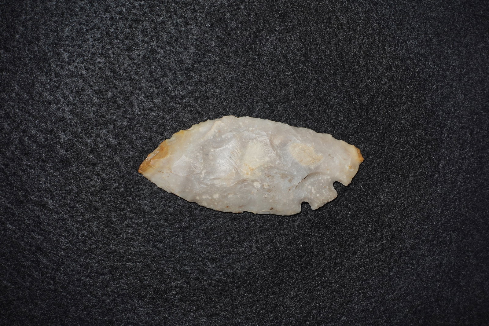 Mid Back Tang: Flaked stone mid-back tang knife/point with bifacially worked faces and a notched basal tang. Translucent white to pale cream quartz/chert with tan staining along the edges and prominent flake scars.