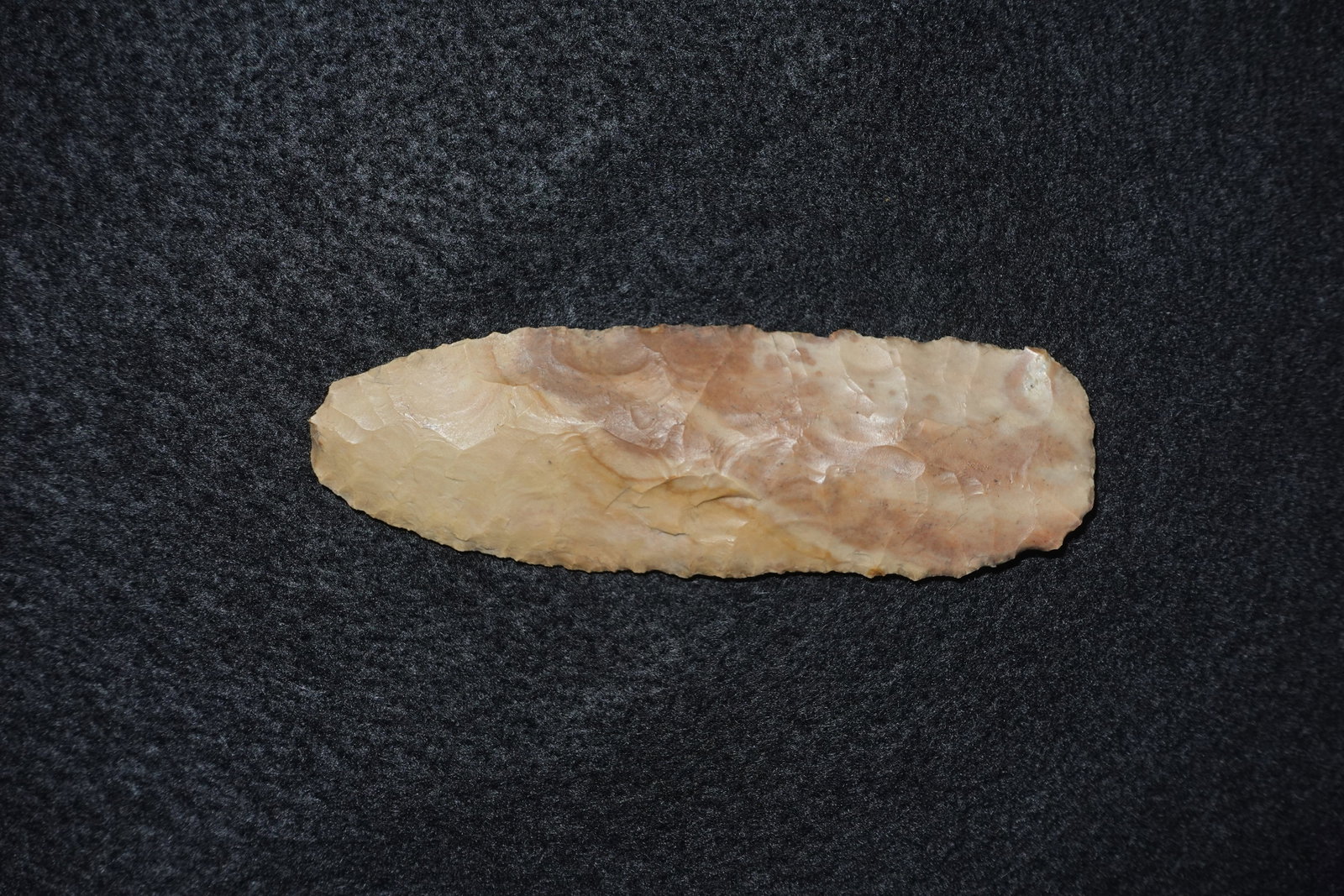 Square Knife: Elongated flaked stone blade with a broad, near-rectangular profile and gently tapered ends. Worked from tan-to-brown chert with pronounced bifacial flake scars and retouched edges, the surface displa