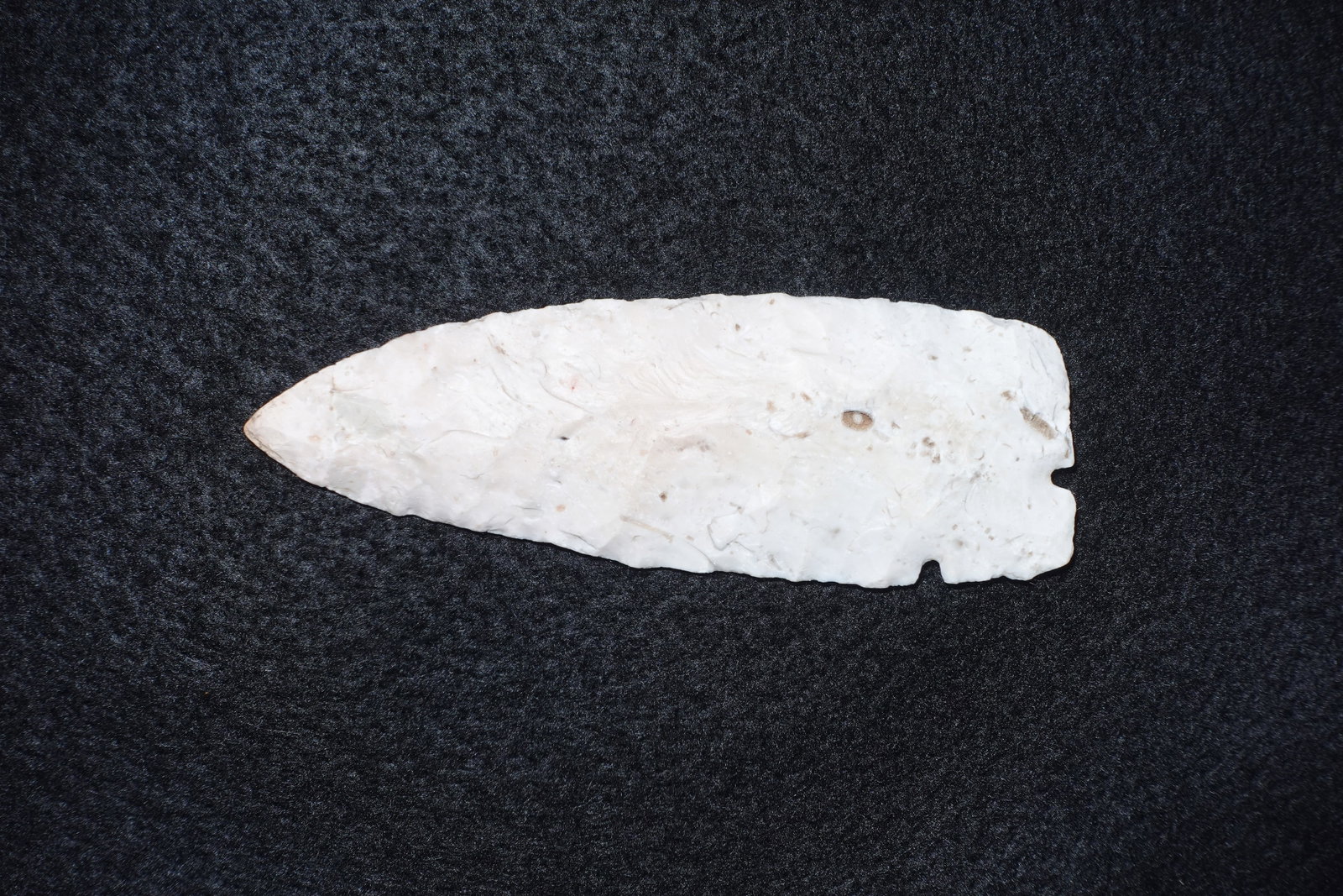 Corner Tang Knife: Flaked white chert knife with a pronounced corner tang and basal notches at the stem. Bifacial flaking and clear flake scars produce a thinned, lanceolate blade with a slightly rounded tip. Surface