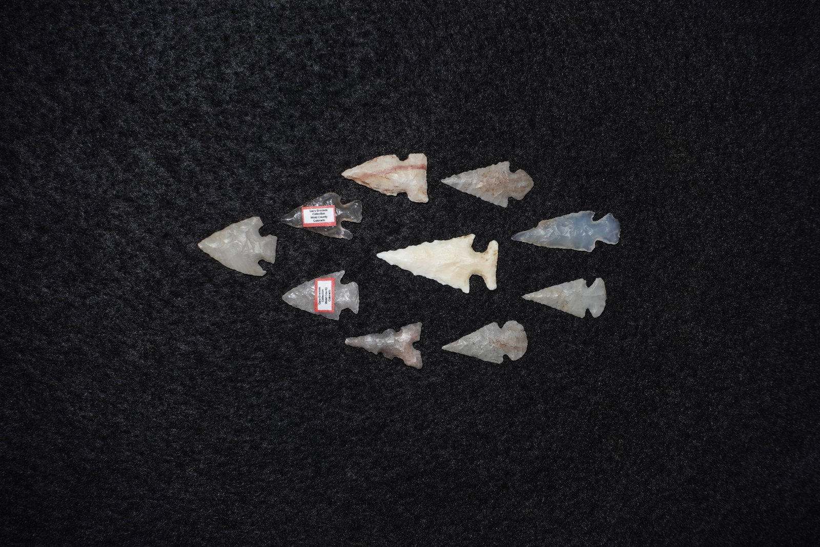Group of Western and High Plains Gem Points: Assorted Western and High Plains-style gem-quality projectile points crafted from translucent to opaque stone in cream, white, gray and bluish tones. Forms include stemmed and notched bases with fine 