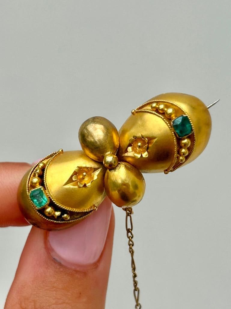 Antique Large Emerald and Gold Brooch with Safety Chain: Antique Large Emerald and Gold Brooch with Safety Chain wonderful gold detailed brooch with sweet emerald stones measurements length 40mm width 18mm weight 5.81g </p
