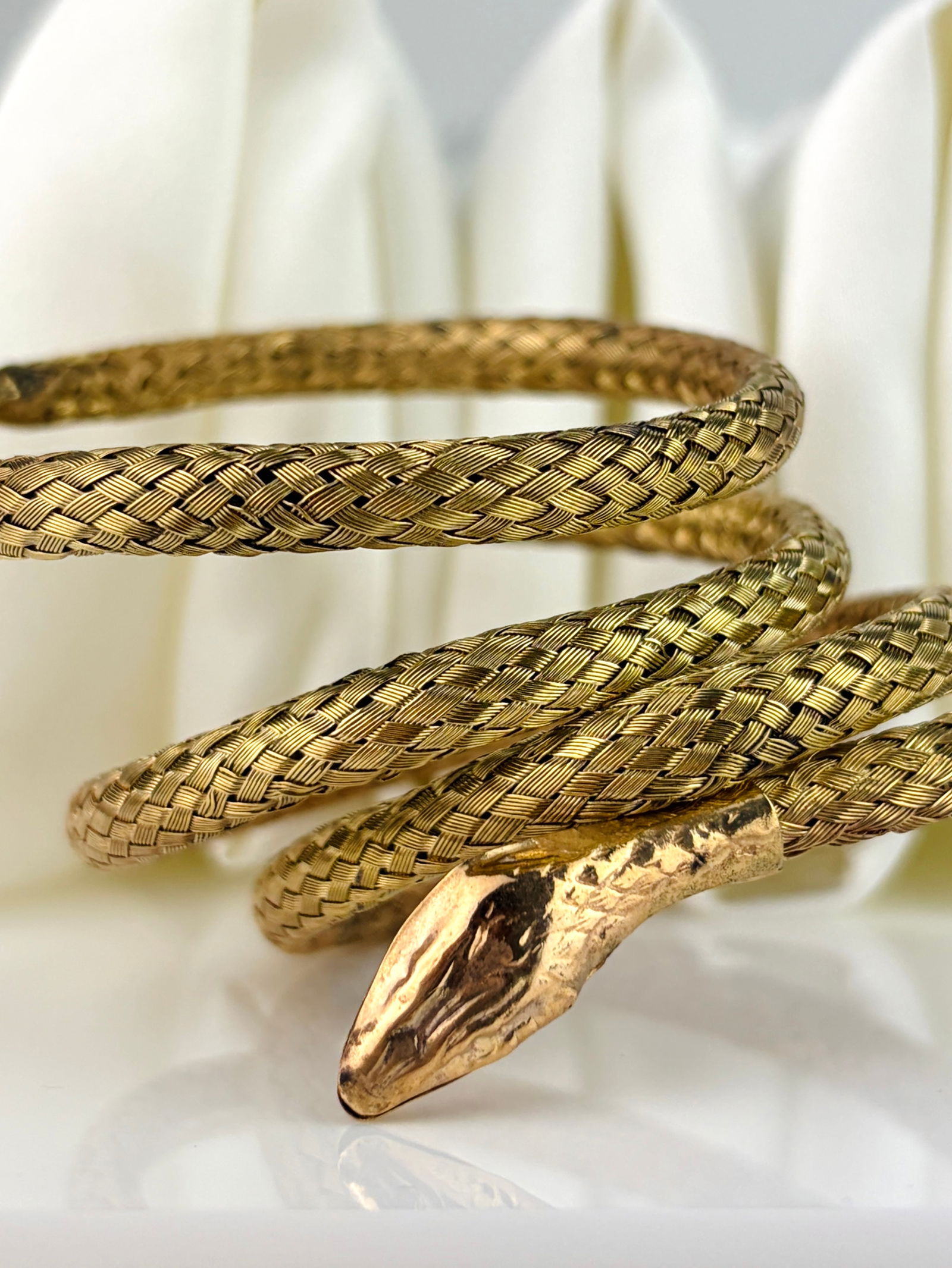 Coiled Snake Bangle in Gilt Metal: Coiled Snake Bangle in Gilt Metal Weight: 17.45g Size: Expands, 38x38mm Inside Materials: Silver Gilt Hallmarks: None present Condition: The overall condition is very good Office Use: