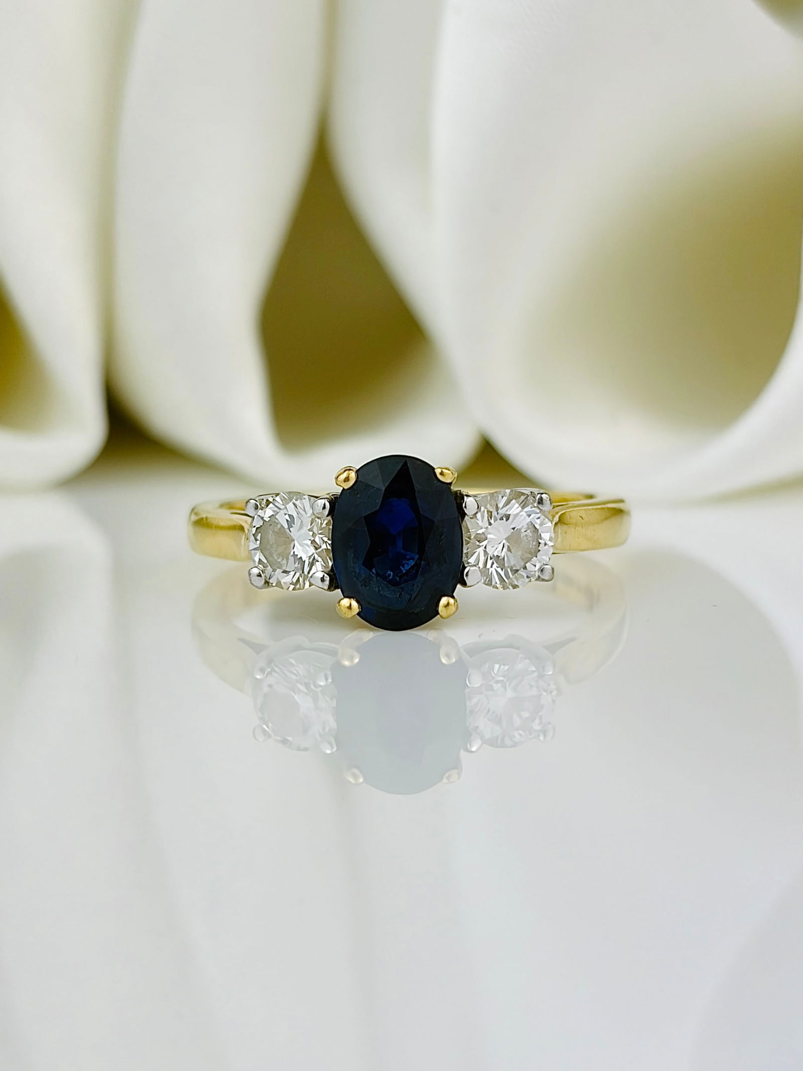 Vintage Sapphire and Diamond 18 Carat Gold Three Stone Ring: Vintage Sapphire and Diamond 18 Carat Gold Three Stone Ring This ring is so pretty holding a 75pt sapphire at the centre and a 25pt diamond either side. Modelled in 18 carat gold and fully