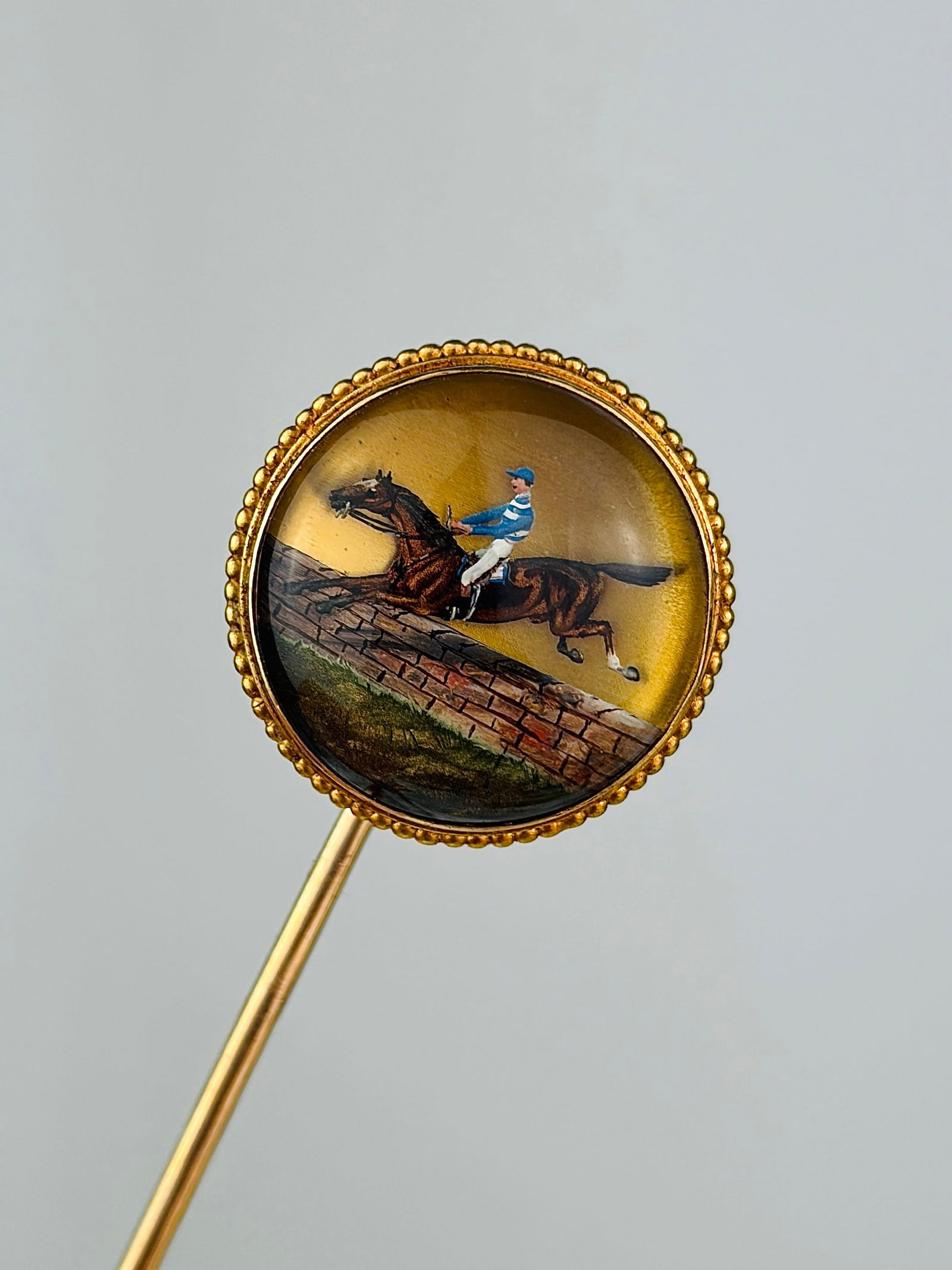 Antique Essex crystal horse and jockey stick pin brooch in gold: Antique Essex crystal horse and jockey stick pin brooch in gold Weight: 6.88g Size: Head 19.5x19.5mm, depth 7.5mm, stick pin length 77mm Materials: Gold Hallmarks: None