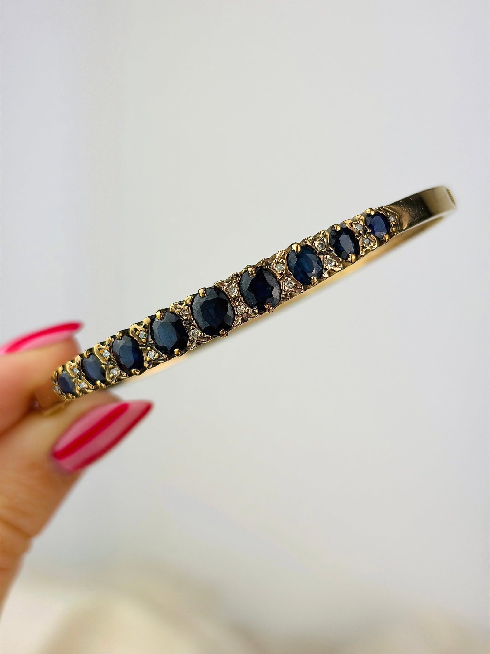 Chunky vintage 9ct yellow gold sapphire and diamond bangle bracelet: Chunky vintage 9ct yellow gold sapphire and diamond bangle bracelet Charming bangle with graduated sapphire stones, spaced with pairs of sparkling diamonds!