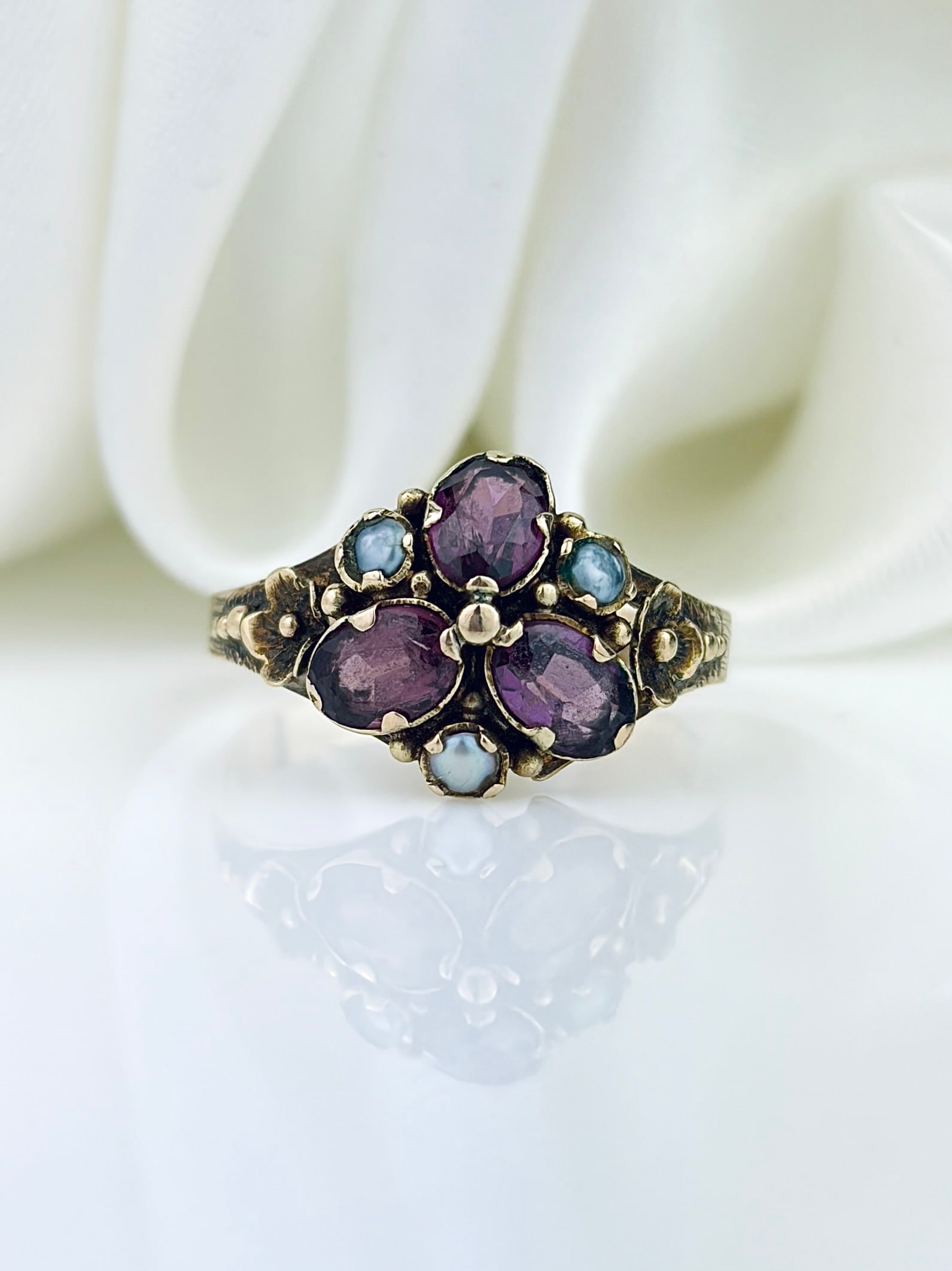 ANTIQUE VICTORIAN GOLD AMETHYST AND PEARL CLUSTER RING: ANTIQUE VICTORIAN GOLD AMETHYST AND PEARL CLUSTER RING Charming ring crafted in the Victorian era, with three amethyst's in a flower formation with a pearl centre and points! Weight: