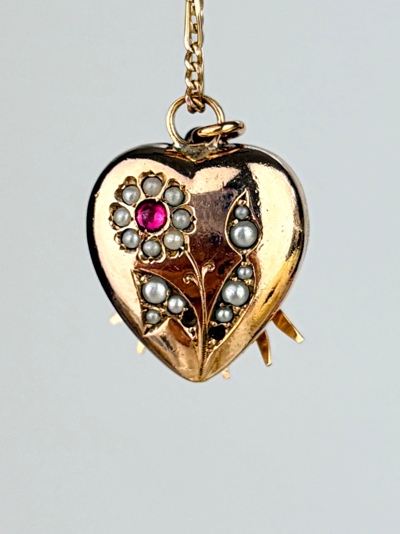 Antique Ruby and Pearl Flower Heart Pendant: Antique Ruby and Pearl Flower Heart Pendant Weight: 3.09g Size: 20x15mm, depth 5mm Materials: Gilt metal Hallmarks: None present Condition: The overall condition is very good, there are two
