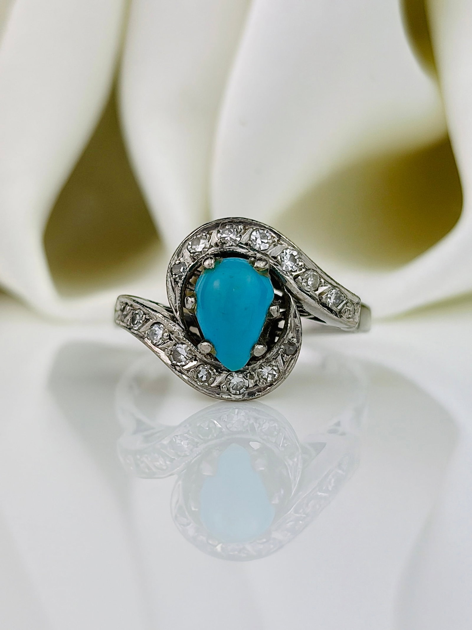 Vintage Diamond and Turquoise Platinum Swirl Ring: Vintage Diamond and Turquoise Platinum Swirl Ring The swirl design of this ring suits the shape of the turquoise stone perfectly. Weight: 4.95g Size: UK P, US 7.75, Width 13mm,