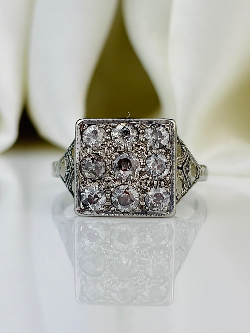 Art Deco Diamond and Platinum Panel Ring: Art Deco Diamond and Platinum Panel Ring This show stopping piece holds a total of nine diamonds measuring 7pts each. The design of this ring has a very Art Deco feel to it which is even shown in th