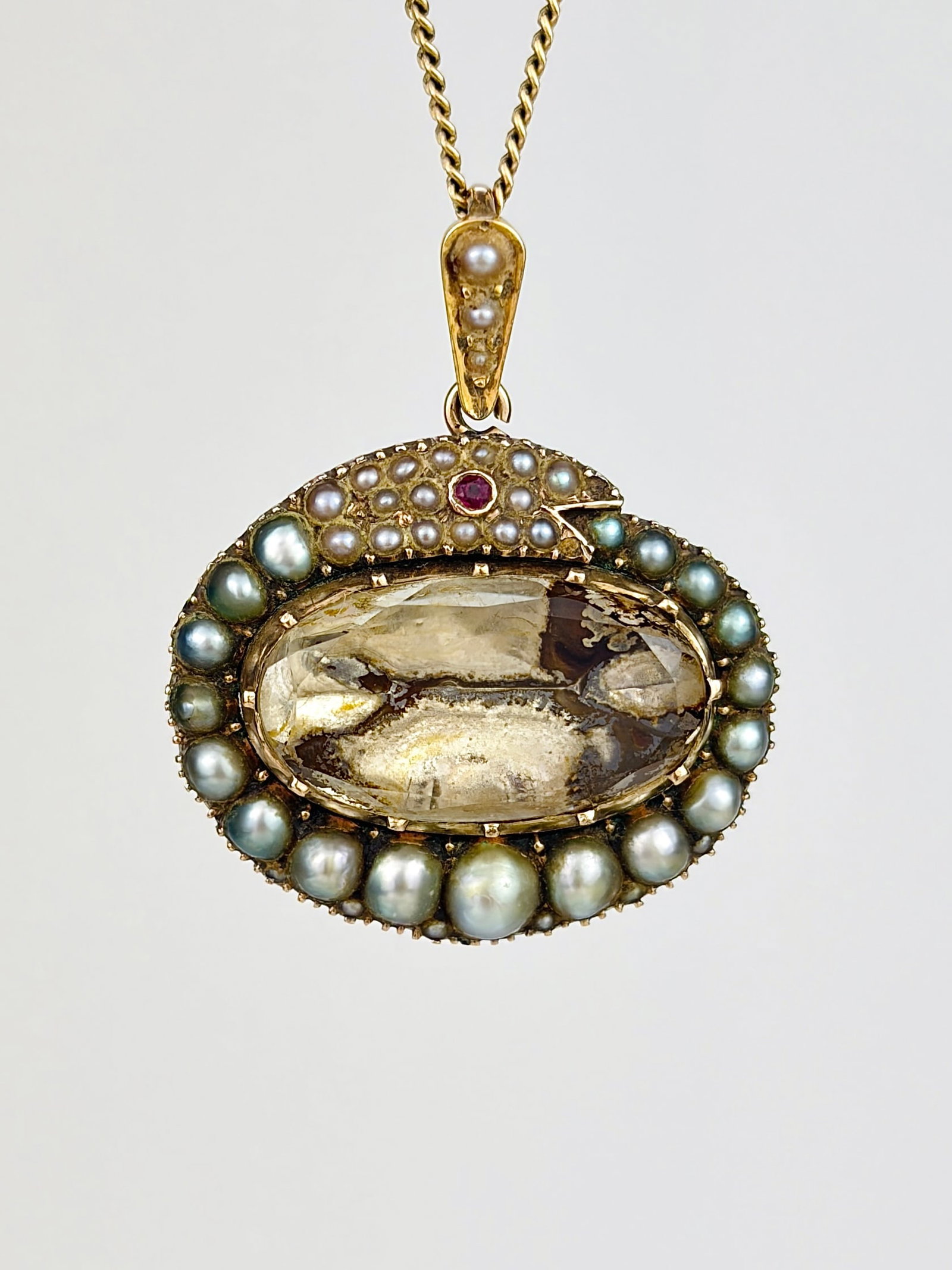 ANTIQUE GEORGIAN ERA GOLD FOILED BACK ROCK CRYSTAL, PEARL AND RUBY EYE SNAKE OUROBOROS PENDANT: ANTIQUE GEORGIAN ERA GOLD FOILED BACK ROCK CRYSTAL, PEARL AND RUBY EYE SNAKE OUROBOROS PENDANT A truly sensational pendant dating back to the Georgian era, sporting a central foiled back rock crystal