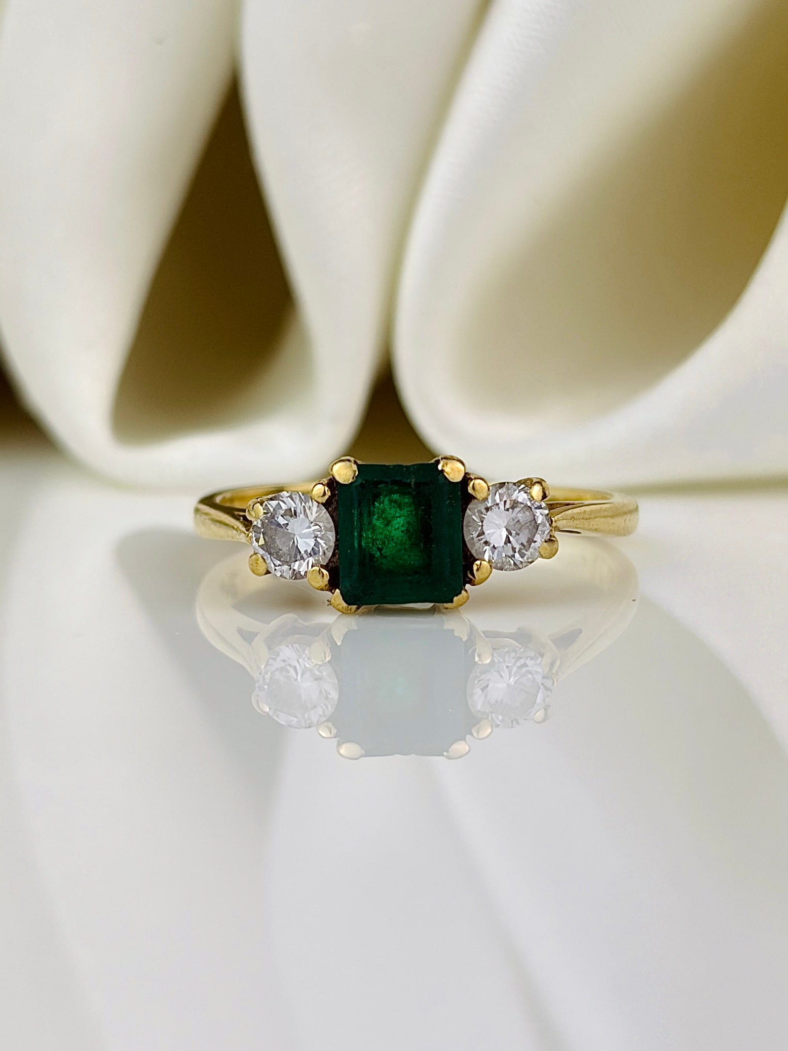 sweet 18ct yellow gold emerald and diamond 3 stone ring: sweet 18ct yellow gold emerald and diamond 3 stone ring Wonderful bright green emerald! Weight: 2.24g Size: UK H, US 4.25, Face of ring 5x10mm, Height off finger 3.5mm Materials: 18ct yellow