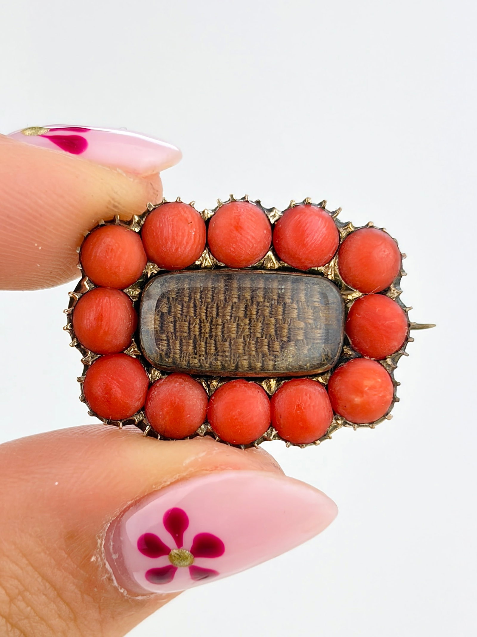 ANTIQUE CORAL AND HAIR LOCKET FRONT BROOCH IN GOLD: ANTIQUE CORAL AND HAIR LOCKET FRONT BROOCH IN GOLD Weight: 4.15g Size: 18x25mm Materials: Gold, coral, hair Hallmarks: None present Condition: Good overall condition. Some signs of wear