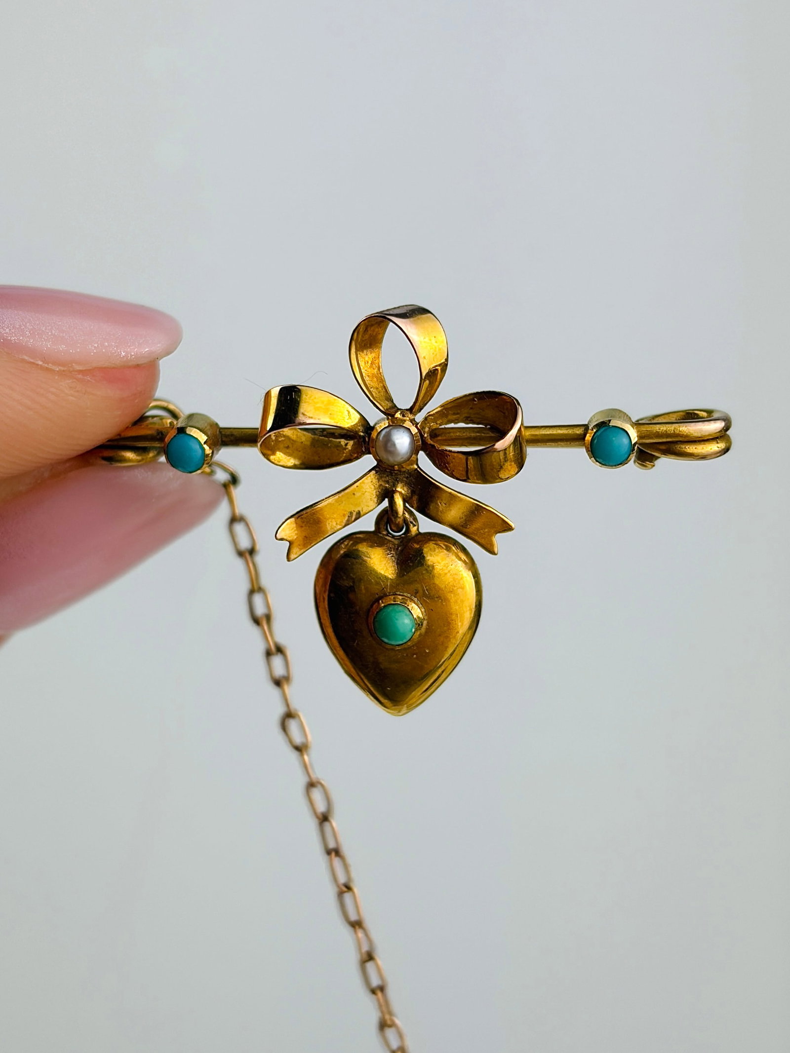 Sweet Antique 9ct Gold Hanging Heart Bow Brooch Set with Turquoise in Original Fitted Box: sweet antique 9ct gold hanging heart bow brooch set with turquoise in original fitted box Weight: 2.7g Size: 21x33mm Materials: 9ct gold Hallmarks: None present Condition: The overall