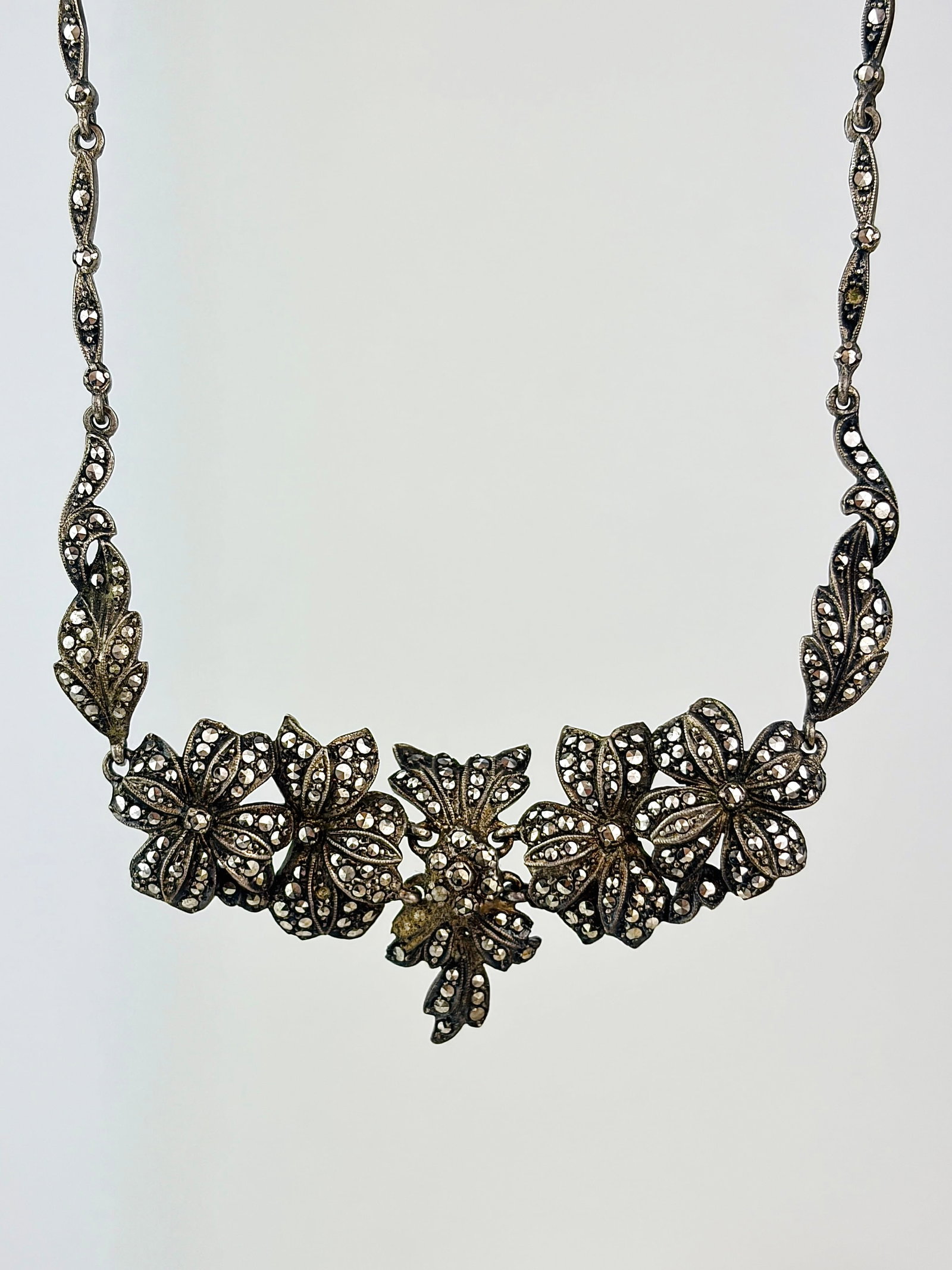antique silver marcasite floral necklace: antique silver marcasite floral necklace Weight: 27.35g Size: Length 57.5cm, drop 28mm Materials: Silver Hallmarks: Faded stamp Condition: Good overall condition. Some signs of wear are expected