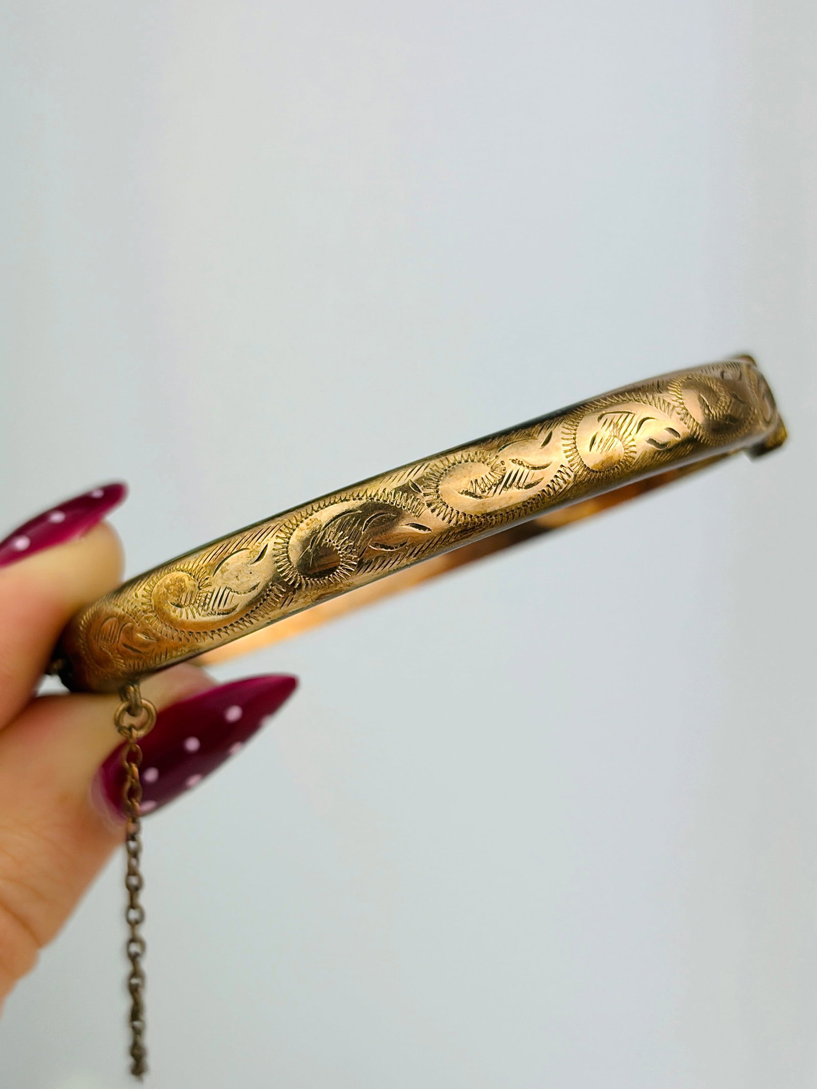 vintage 9ct rolled gold bangle with safety chain: vintage 9ct rolled gold bangle with safety chain Weight: 8.6g Size: Inner circumference 17cm, 6mm width Materials: rolled gold Hallmarks: 1/5th 9carat rolledgold stamp Condition: Good