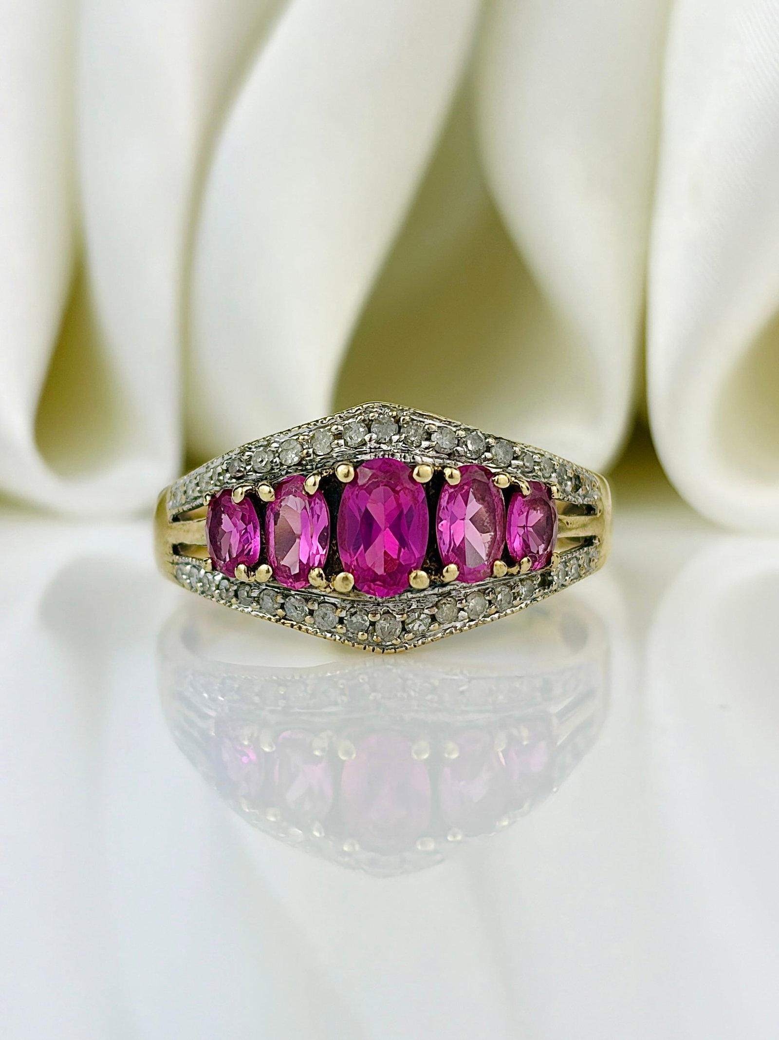 Vintage 9 Carat Pink Sapphire and Diamond Ring: Vintage 9 Carat Pink Sapphire and Diamond Ring The most stunning bright pink sapphires with a larger centre stone. All framed by a line of sparkling diamonds. ASSAYED IN BIRMINGHAM 9 CARAT GOLD