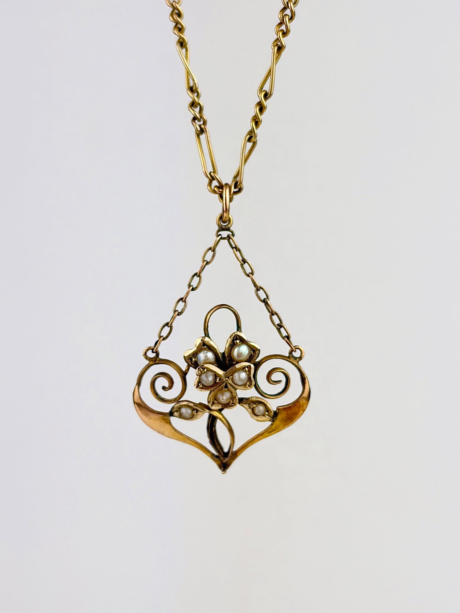 ANTIQUE 9CT GOLD PEARL ORNATE PENDANT ON GOLD FIGARO CHAIN: ANTIQUE 9CT GOLD PEARL ORNATE PENDANT ON GOLD FIGARO CHAIN Such a sweet pendant! Weight: 5.24g Size: Pendant 37x22mm, chain length 38.2cm Materials: 9ct gold, pearl Hallmarks: 9ct stamp