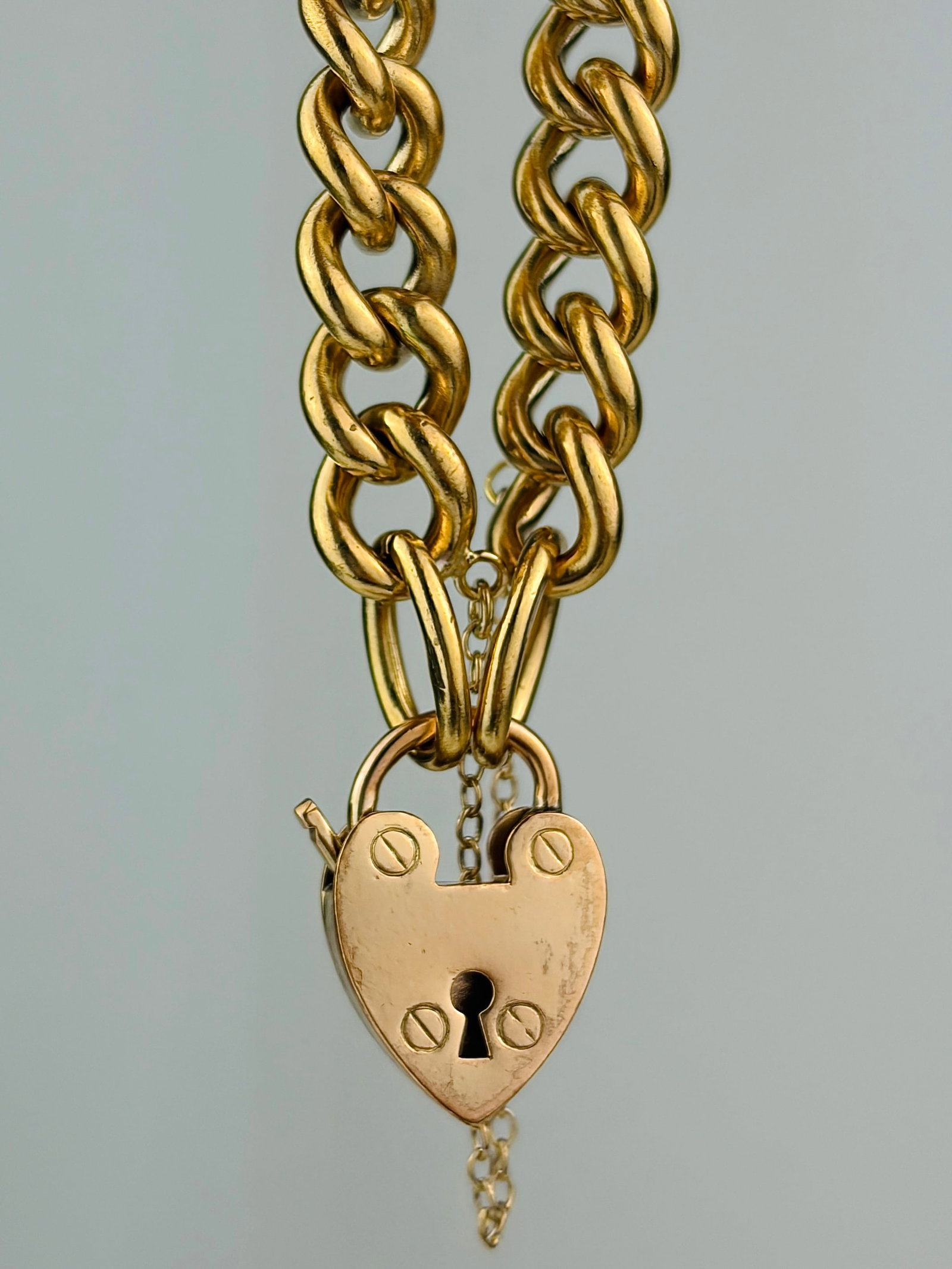 CHUNKY ANTIQUE CURB LINK BRACELET WITH HEART PADLOCK: CHUNKY ANTIQUE CURB LINK BRACELET WITH HEART PADLOCK NOT GOLD Weight: 32.46g Size: Length 22cm, link width 8mm Materials: not gold Condition: Very good overall condition. Some signs of