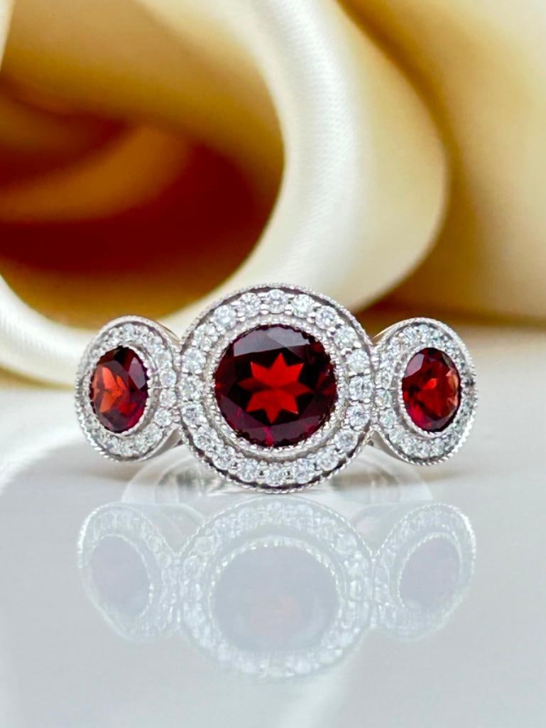 Chunky 18ct White Gold Garnet and Diamond 3 Stone Halo Ring: Chunky 18ct White Gold Garnet and Diamond 3 Stone Halo Ring Outstanding glowing garnets with diamonds surrounding truly exceptional measurements size uk L us 6 head of ring 25mm x