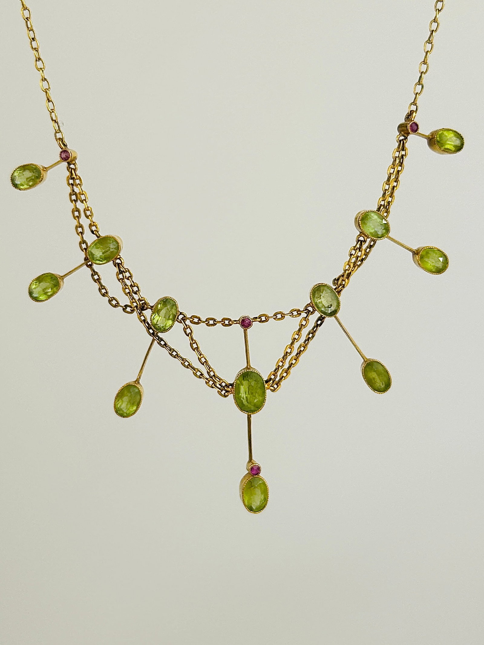 Wonderful Antique Peridot and Ruby 9ct Gold Drop Necklace with Safety Chain: Wonderful Antique Peridot and Ruby 9ct Gold Drop Necklace Weight: 6.88g Size: Length 39cm, Drop 3.5cm Materials: 9ct Gold Hallmarks: Stamped 9ct Condition: The overall condition is very good