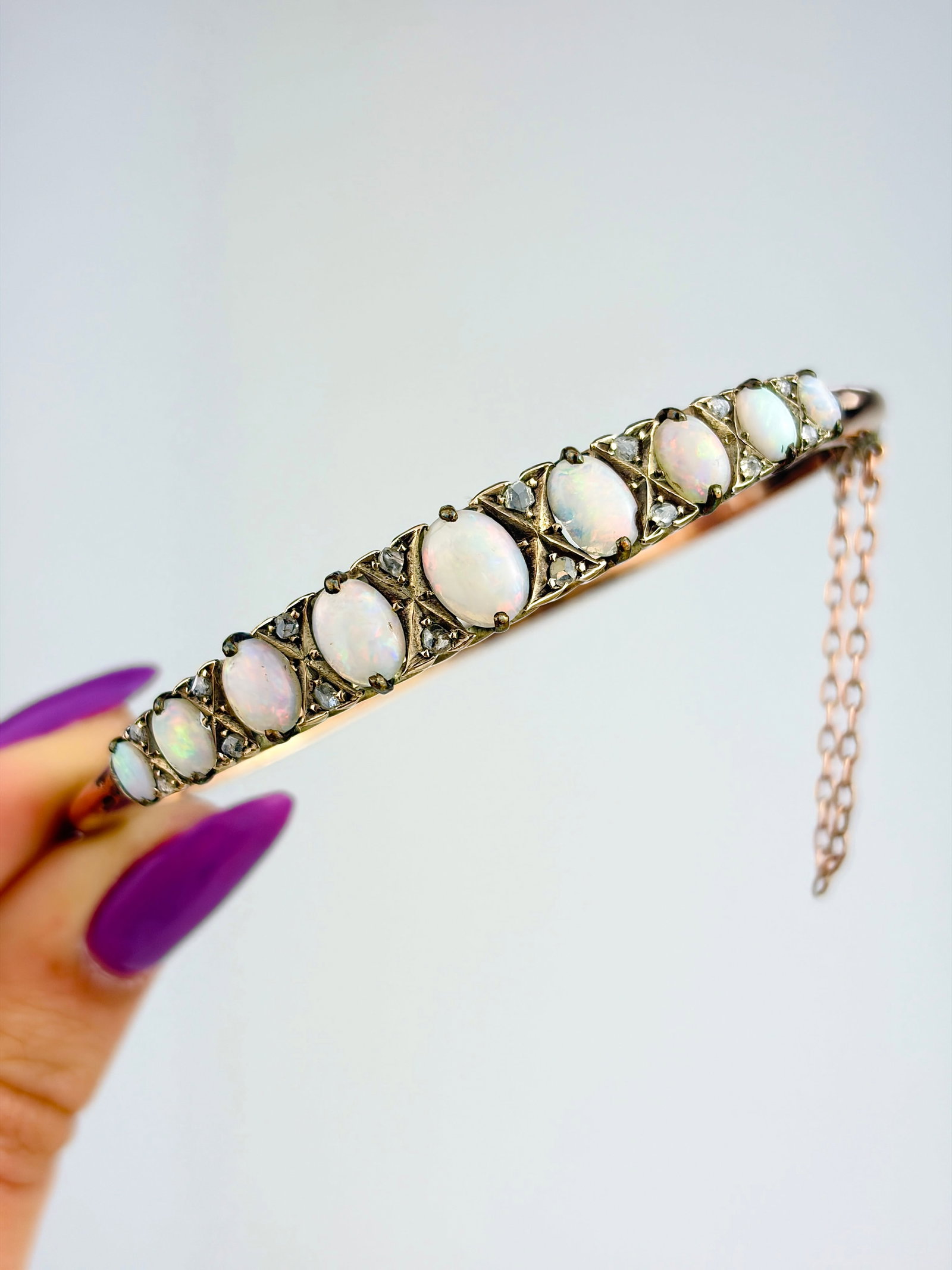 ANTIQUE OPAL AND DIAMOND 9ct GOLD BANGLE BRACELET: ANTIQUE OPAL AND DIAMOND 9ct GOLD BANGLE BRACELET Exquisite opal stones separated by stacked diamonds! Weight: 12.65g Size: Inner circumference 16.5cm, widest point 7.5mm Materials: 9ct