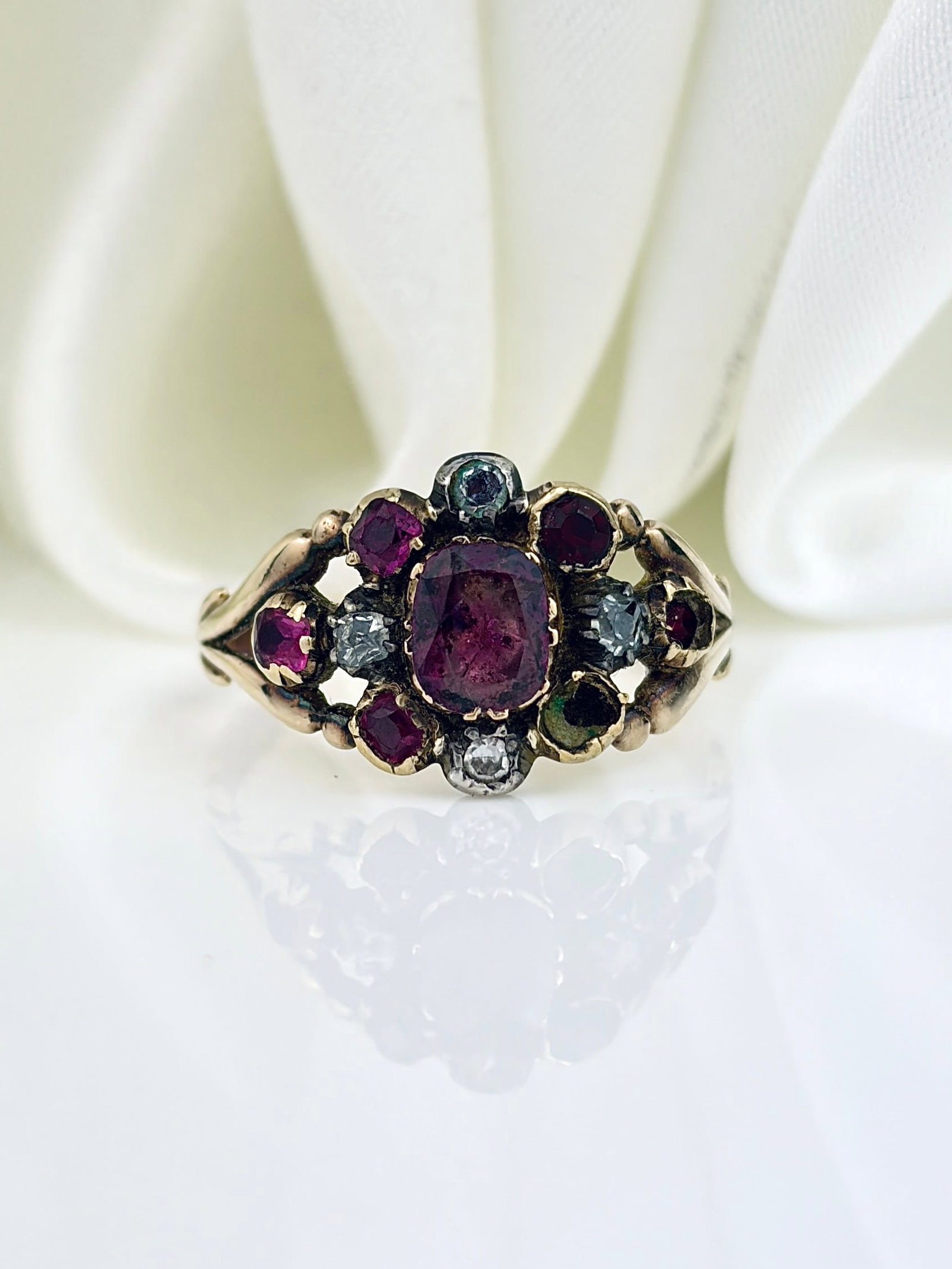 ANTIQUE GOLD RUBY AND PASTE CLUSTER RING: ANTIQUE GOLD RUBY AND PASTE CLUSTER RING Weight: 2.5g Size: UK P, US 8, Width 11mm, height off finger 2mm Materials: Gold Hallmarks: None present Condition: Good overall condition,