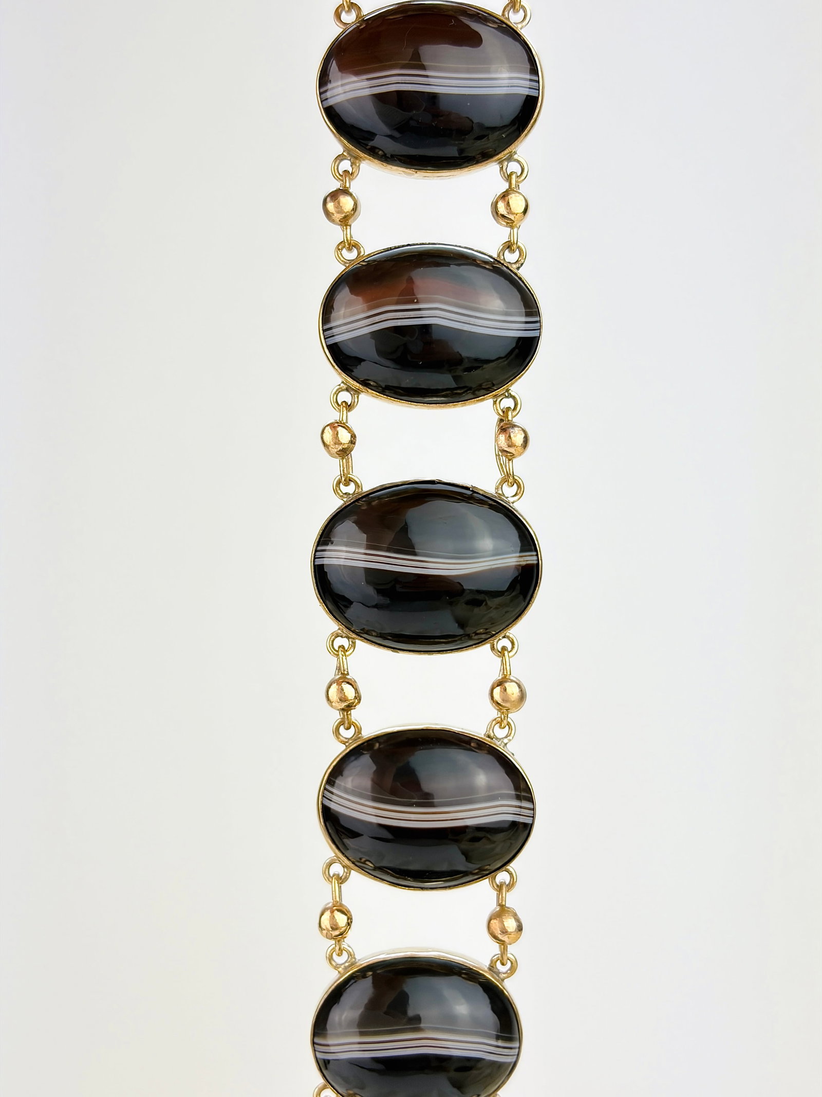 ANTIQUE LARGE BANDED AGATE BRACELET IN GILT METAL: ANTIQUE LARGE BANDED AGATE BRACELET IN GILT METAL Weight: 46.65g Size: Length 17.5cm, Width 23mm, depth 8mm Materials: Gilt metal, agate Hallmarks: None present Condition: Very good