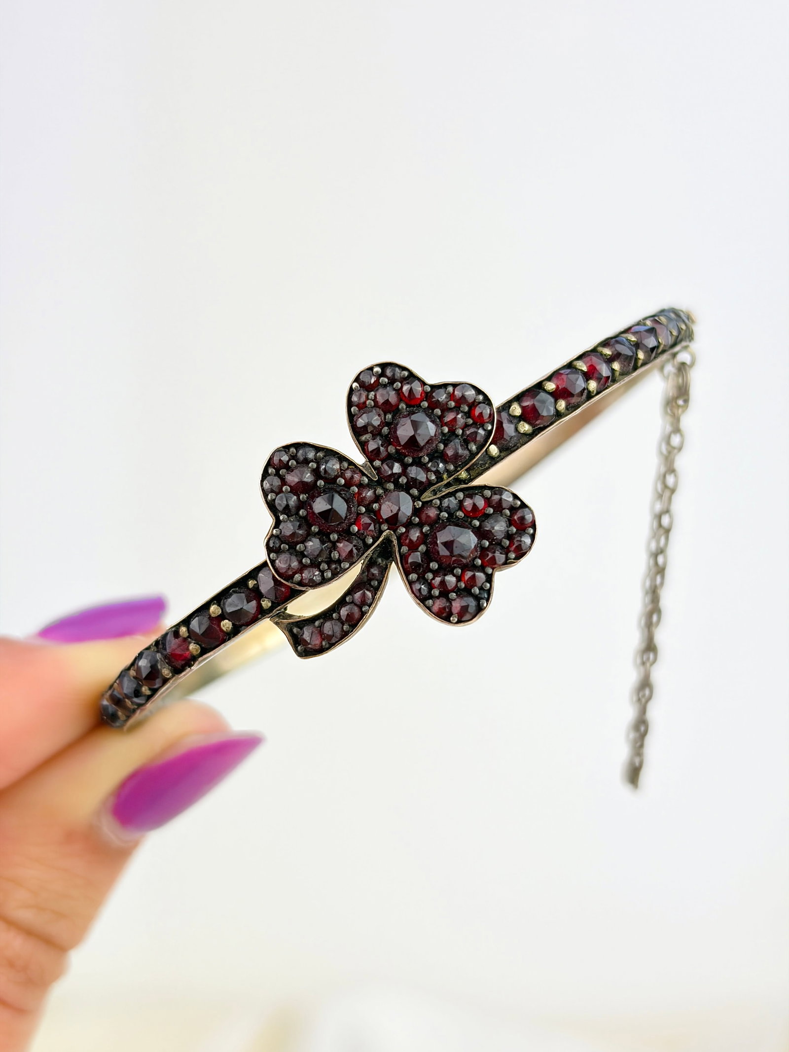 ANTIQUE BOHEMIAN GARNET PANSY BANGLE BRACELET: ANTIQUE BOHEMIAN GARNET PANSY BANGLE BRACELET Weight: 11.47g Size: Inner circumference 16cm or 48x52mm, width 24mm Condition: Good overall condition, the bracelet is misshapen as shown in the