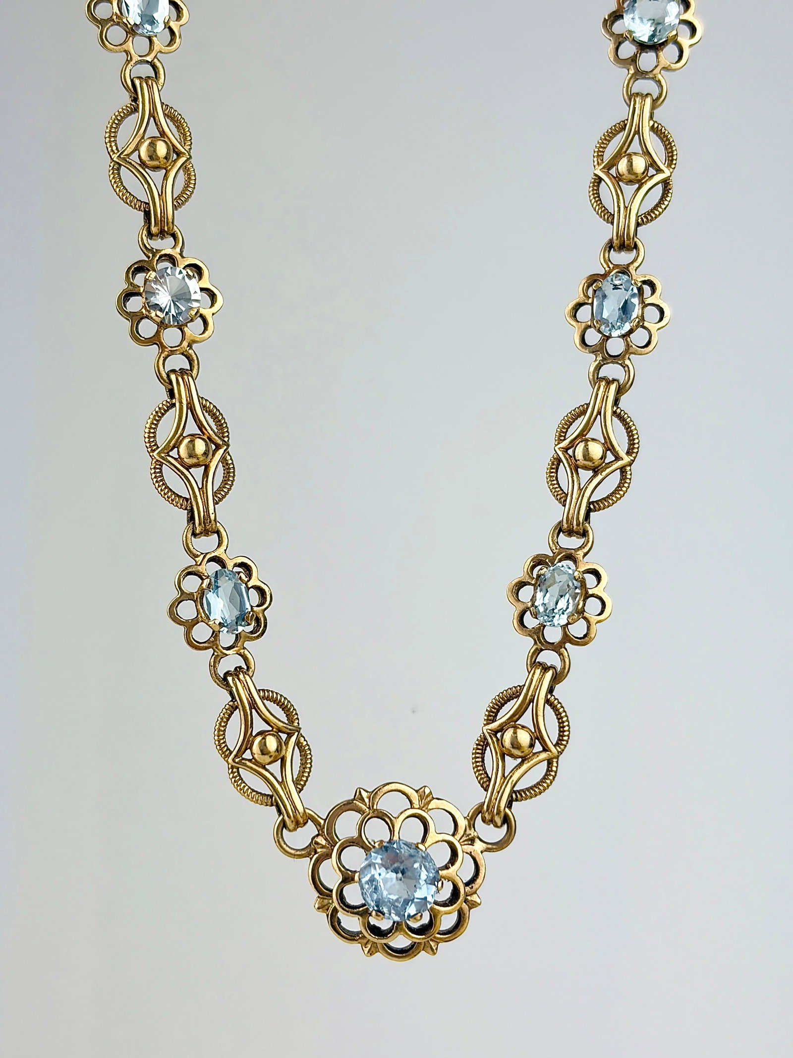 AMAZING 9CT GOLD AND AQUAMARINE RIVIERE STYLE NECKLACE: AMAZING 9CT GOLD AND AQUAMARINE RIVIÈRE STYLE NECKLACE Such a beautiful necklace featuring oval shaped aquamarine stones set in an ornate floral link, spaced by beautiful lattice links!