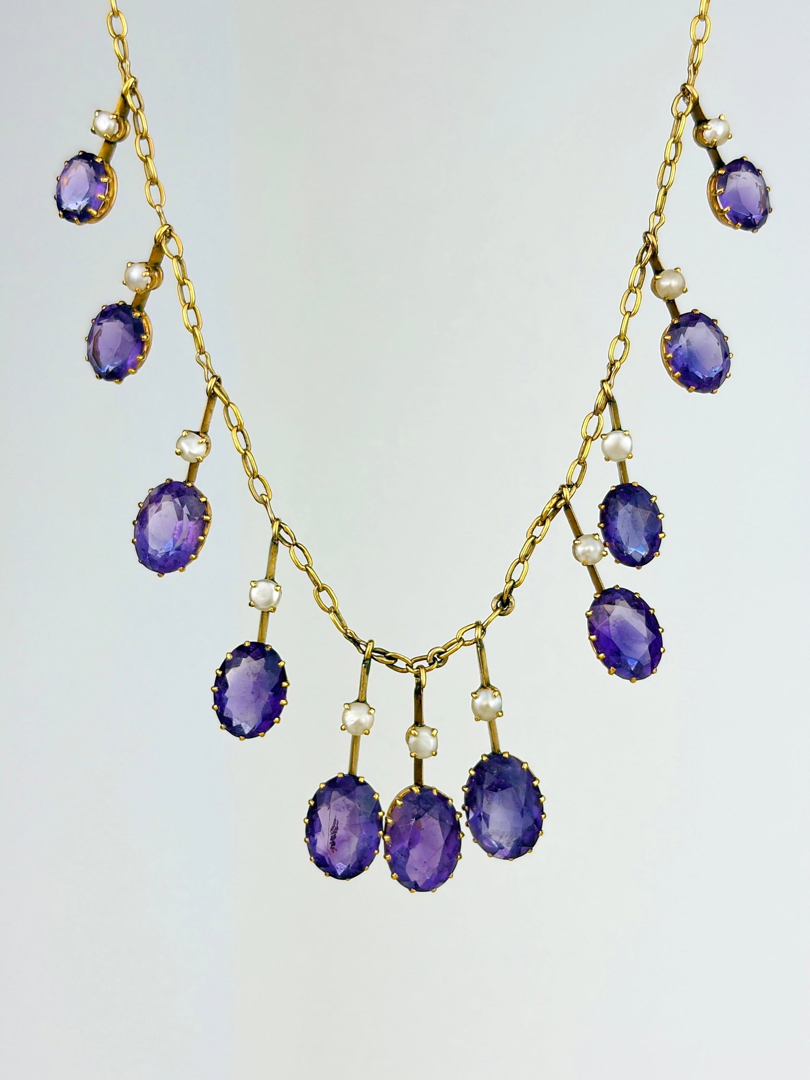 ANTIQUE 9CT YELLOW GOLD AMETHYST AND PEARL FRINGE NECKLACE: ANTIQUE 9CT YELLOW GOLD AMETHYST AND PEARL FRINGE NECKLACE An entrancing necklace with a fringe of amethyst and pearl drops that frame the neck beautifully!