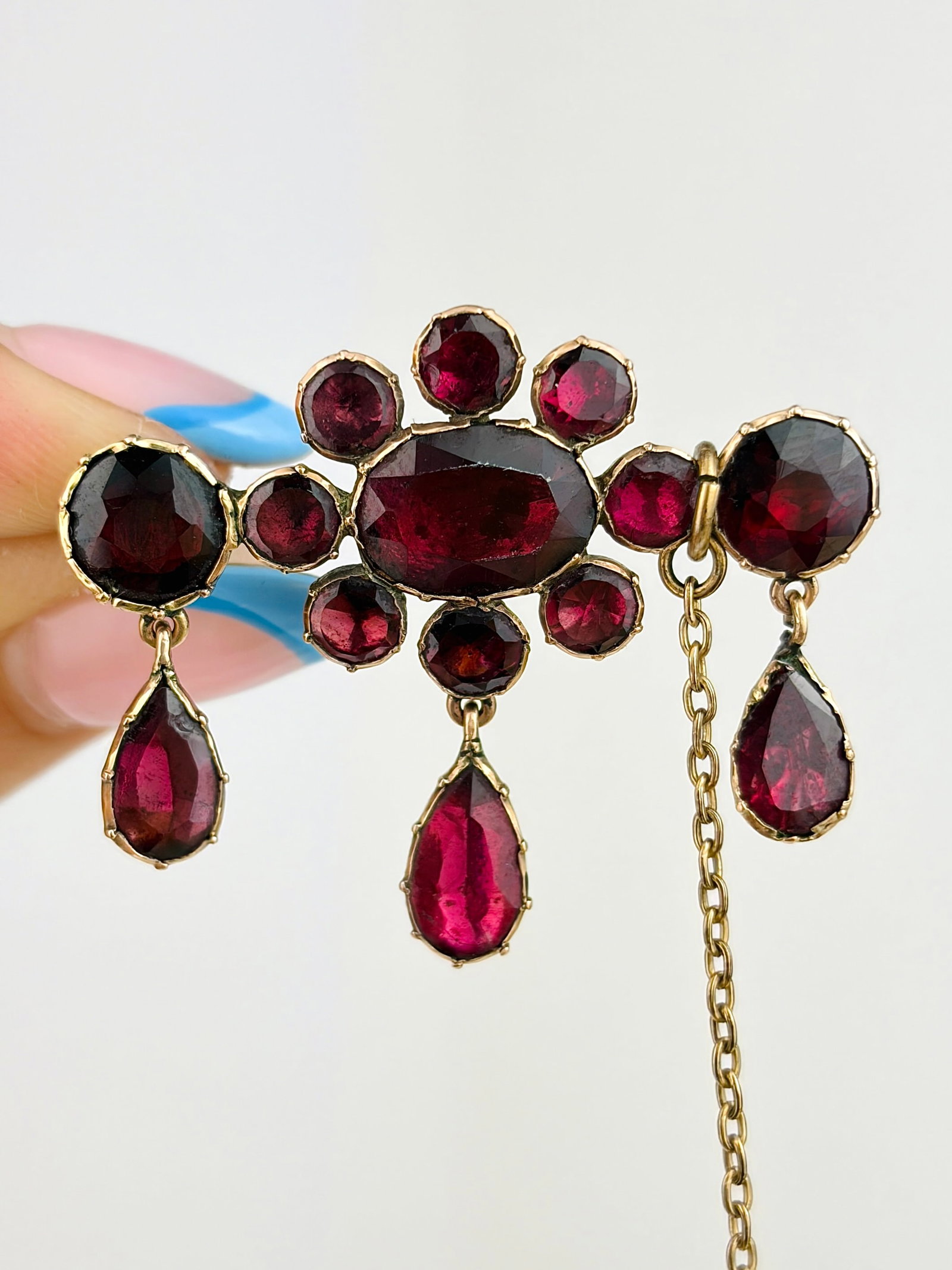 STUNNING ANTIQUE FLAT CUT GARNET FLOWER DROP BROOCH IN GOLD: STUNNING ANTIQUE FLAT CUT GARNET FLOWER DROP BROOCH IN GOLD The most amazing flat cut garnet stones, that are formed as a flower, and littler tear drops! Also with a safety chain for extra security!