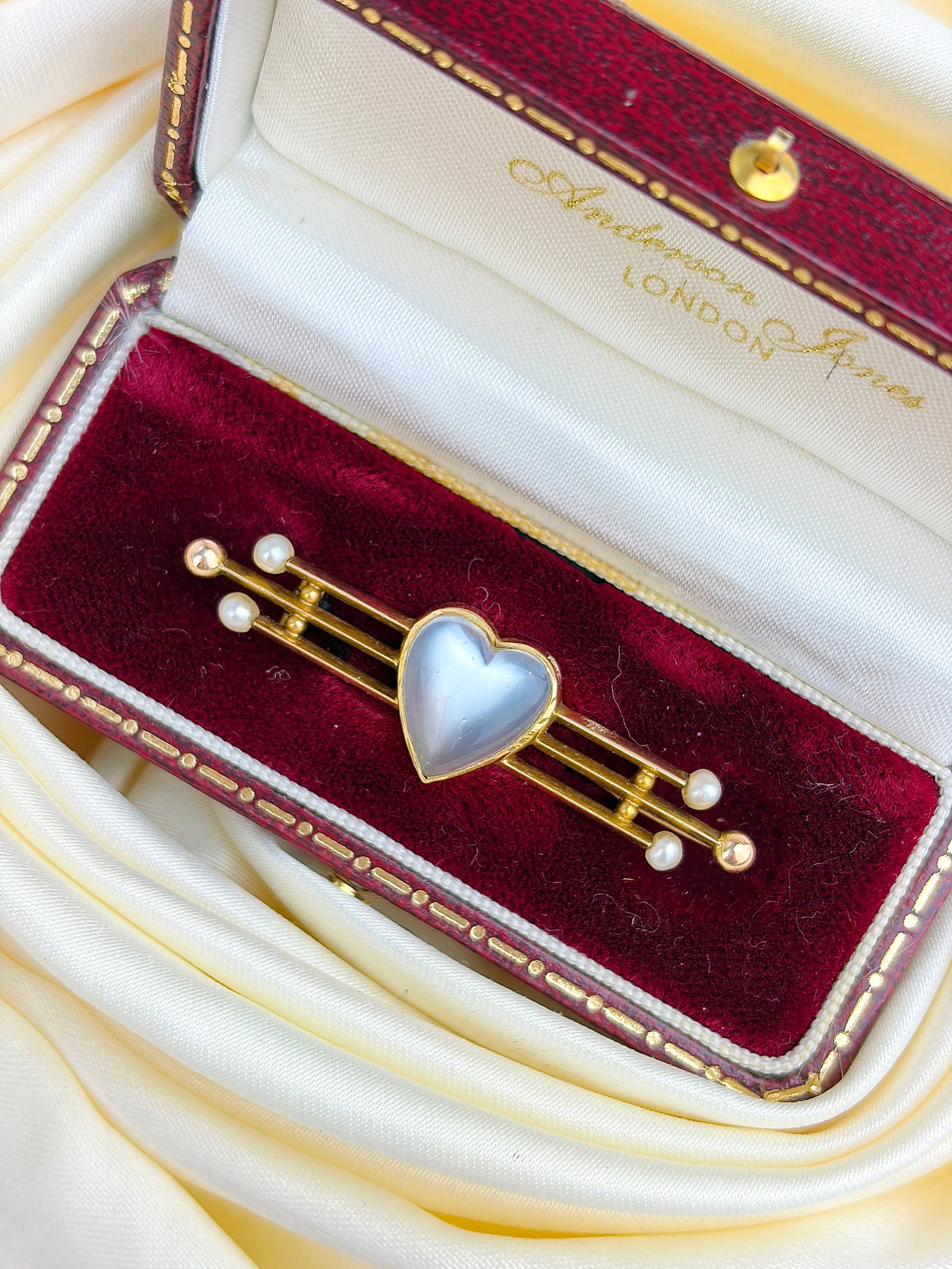 ANTIQUE 18CT YELLOW GOLD MOONSTONE AND PEARL HEART BAR BROOCH IN BOX: ANTIQUE 18CT YELLOW GOLD MOONSTONE AND PEARL HEART BAR BROOCH IN BOX Absolutely stunning brooch featuring a heart cut cabochon moonstone with a lovely pale blue hue, and pearls on each end!