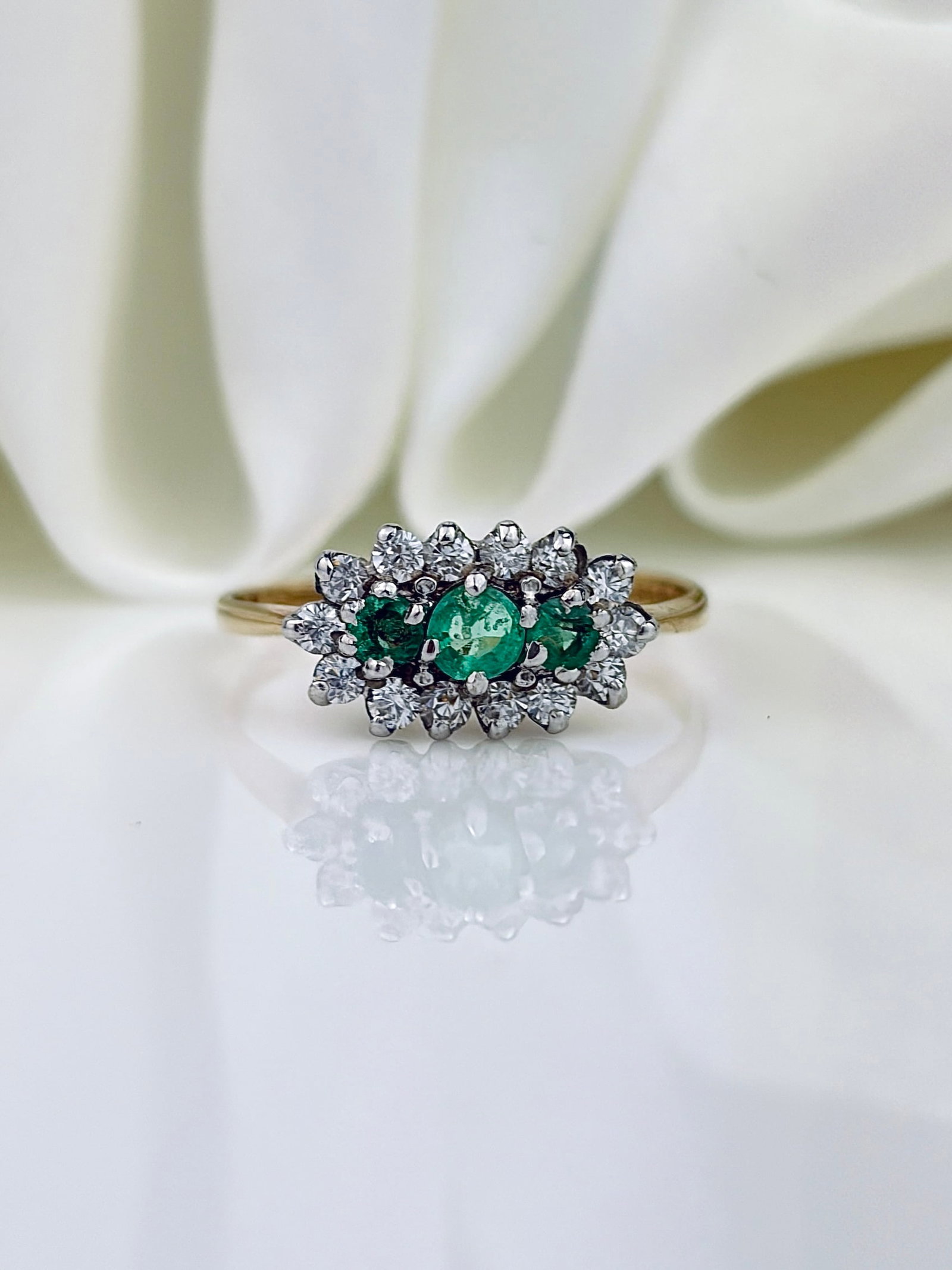 VINTAGE C.1996 9CT YELLOW GOLD EMERALD AND WHITE PASTE TRIPLE CLUSTER RING: VINTAGE C.1996 9CT YELLOW GOLD EMERALD AND WHITE PASTE TRIPLE CLUSTER RING Pretty bright emeralds surrounded by sparkling white paste stones!