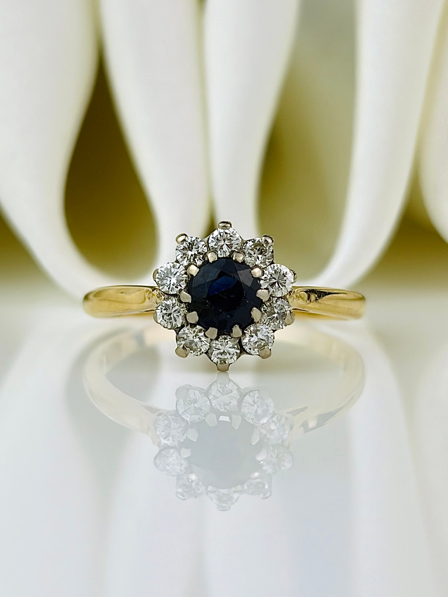 sweet sapphire and diamond flower ring in 18ct yellow gold: sweet sapphire and diamond flower ring in 18ct yellow gold Such a charming ring! Weight: 2.5g Size: UK N, US 7, Face of ring 9.5x9.5mm, Height off finger 5.4mm Materials: 18ct Yellow