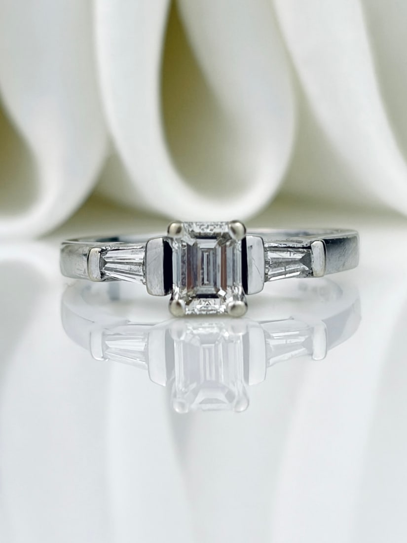 *Vintage Diamond and 18 Carat White Gold Solitaire Ring: Vintage Diamond and 18 Carat White Gold Solitaire Ring The central emerald cut diamond in this ring measures 45pts and is I/J colour VS and has tapered baguette diamonds either side. &nbs