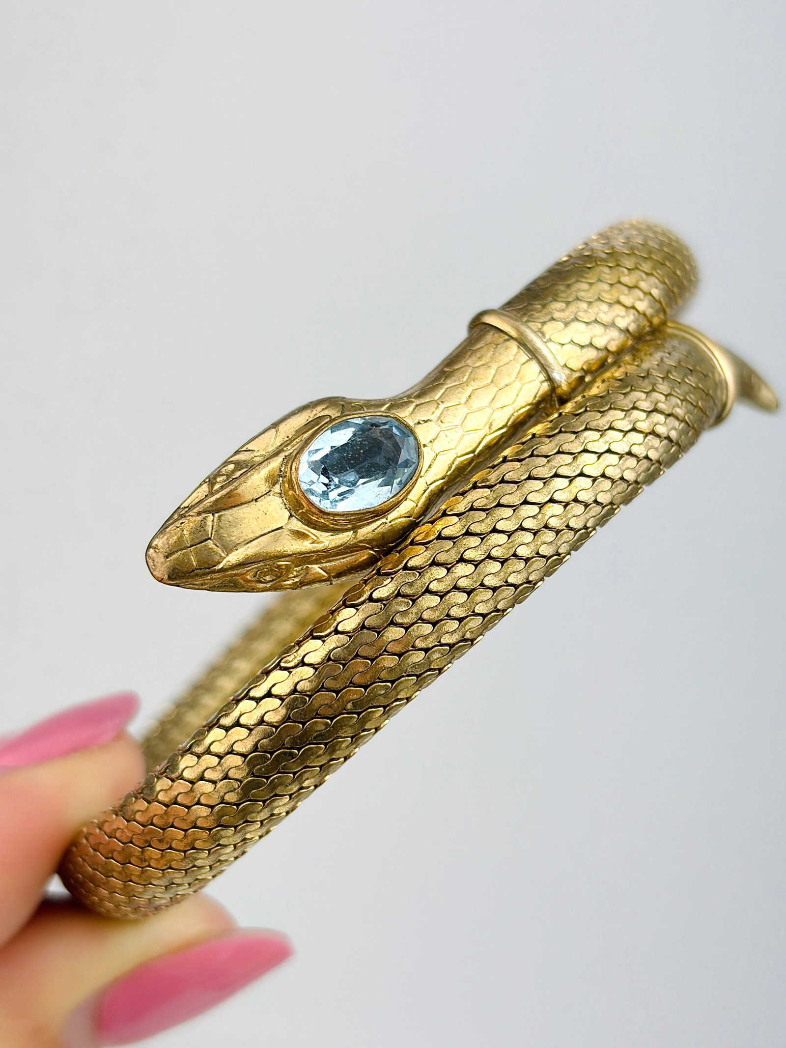 VINTAGE YELLOW METAL COILED SNAKE BANGLE: VINTAGE YELLOW METAL COILED SNAKE BANGLE Weight: 27g Size: 17.5cm, width 18mm Materials: yellow metal Condition: Very good overall condition. Some signs of wear are expected given the