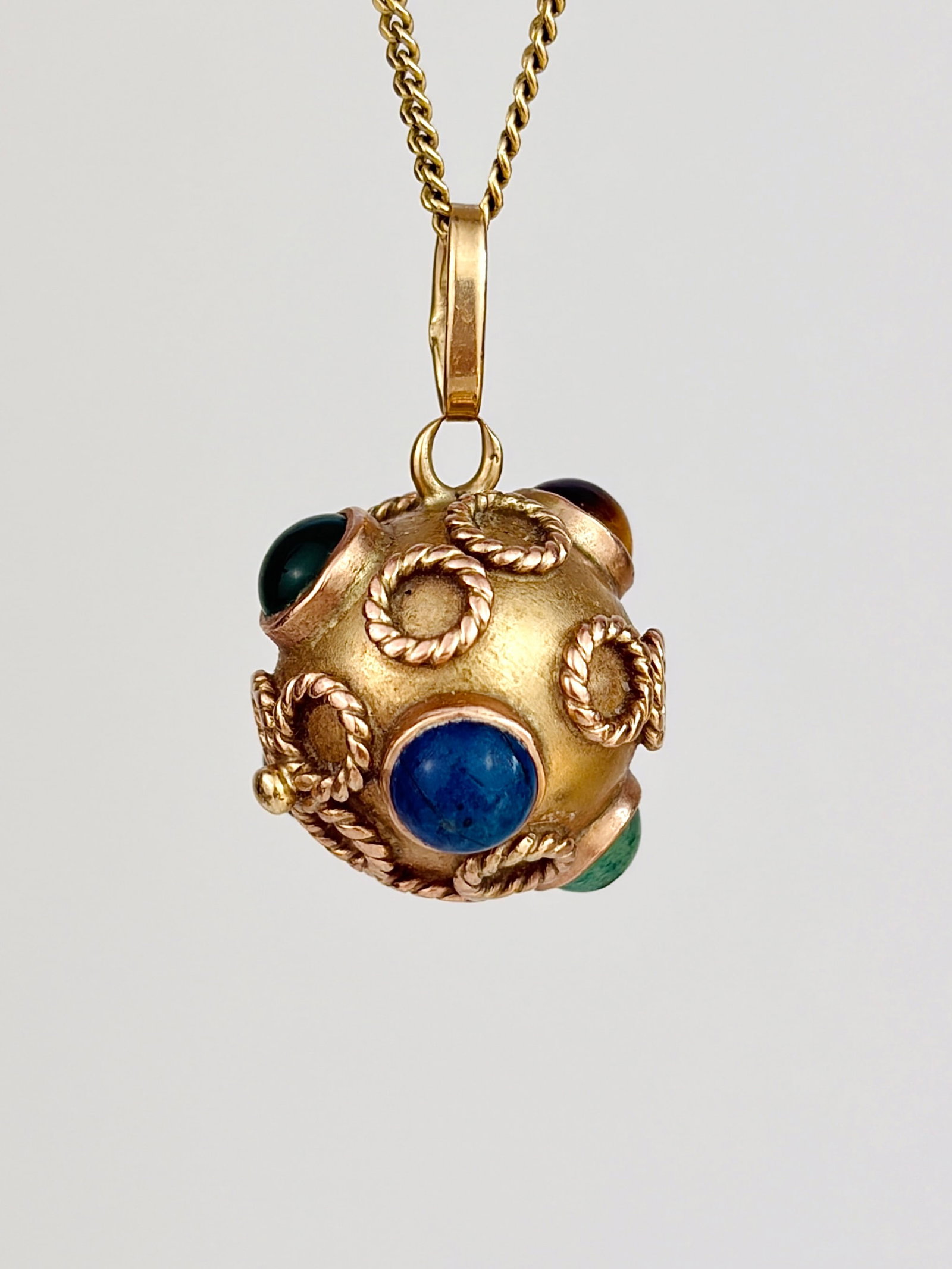 ANTIQUE 18CT YELLOW GOLD GEMSET ORB SPUTNIK PENDANT: ANTIQUE 18CT YELLOW GOLD GEMSET ORB SPUTNIK PENDANT Stunning orb pendant with gemstones and flower details with chalcedony, lapis, tigers-eye and jet Weight: 5.45g Size: 23x16mm Materials: