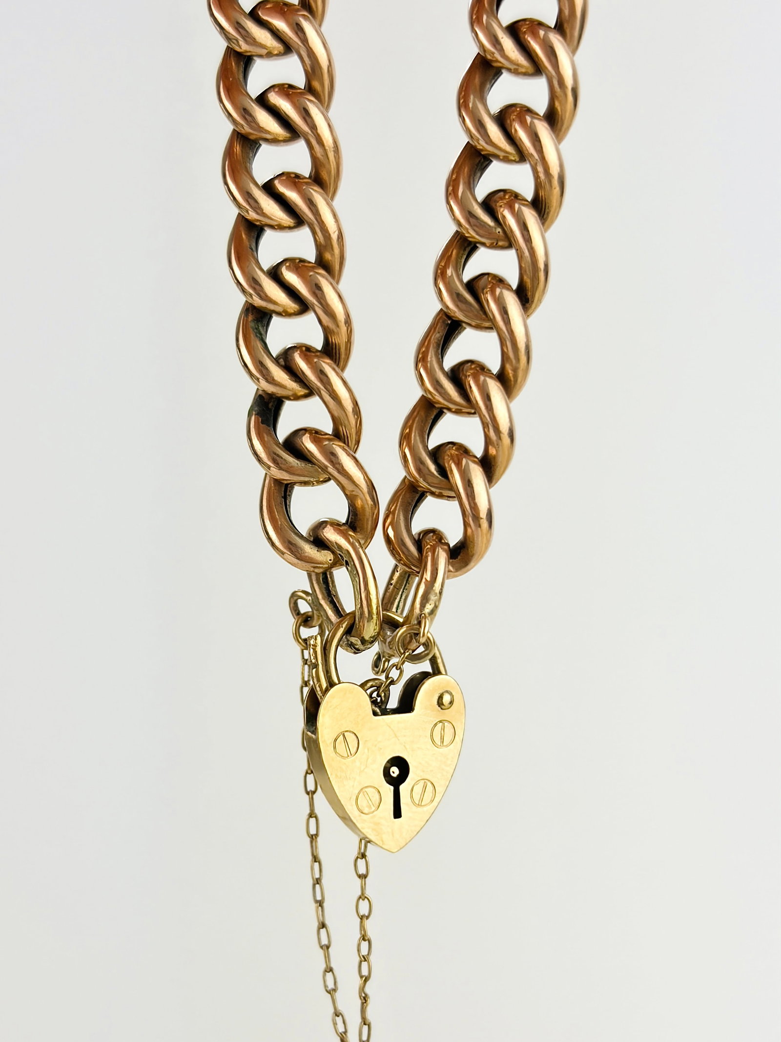 Vintage Chunky 9ct Gold Gate Bracelet with Heart Padlock: Vintage Chunky 9ct Gold Gate Bracelet with Heart Padlock Weight: 13.7g Size: length 18.7cm, width 9mm Materials: 9ct gold Hallmarks: 9ct stamps on each link, 9ct, London, 1980 on padlock