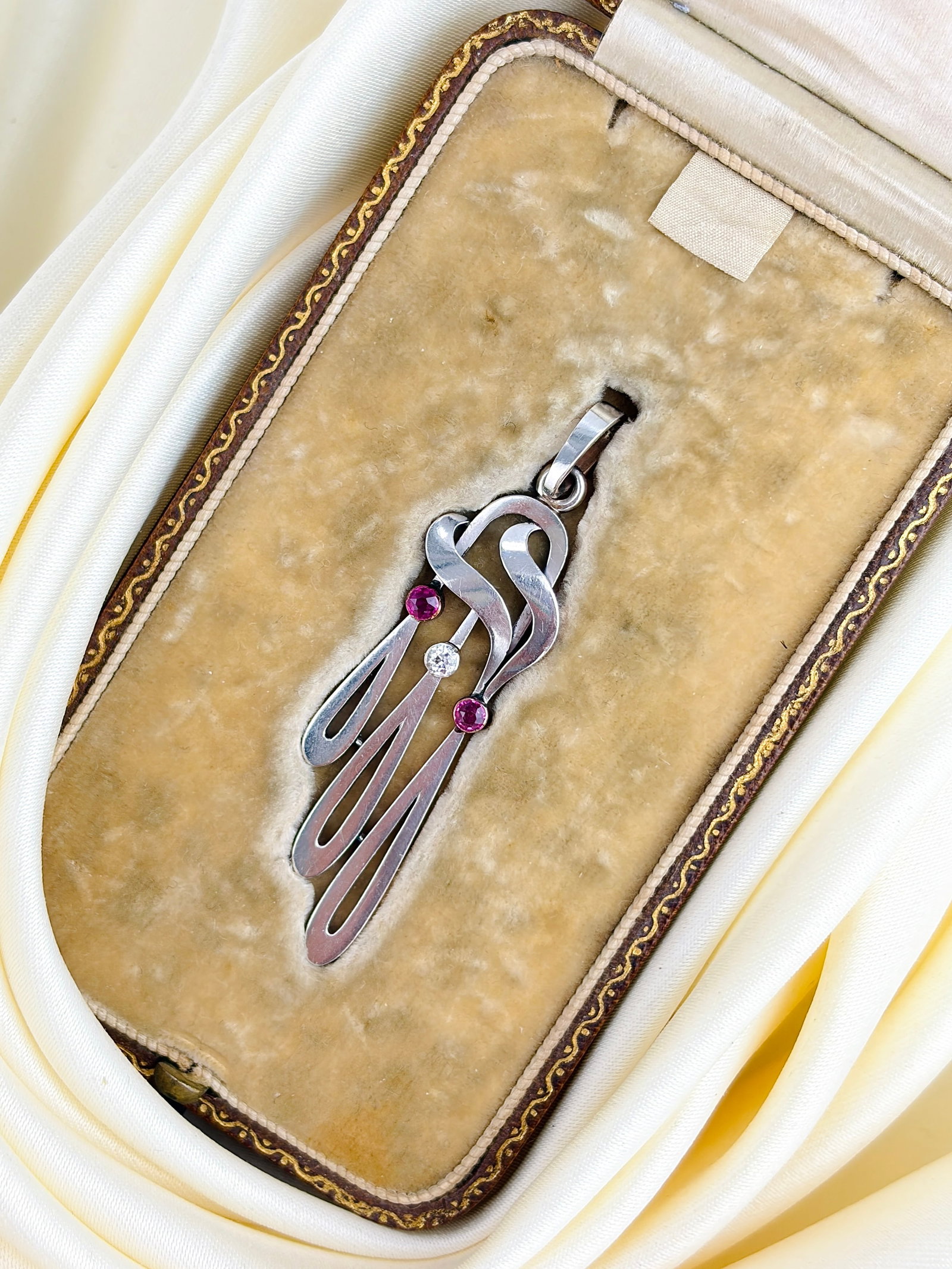 Antique Art Nouveau Boxed Ruby and Diamond Pendant in 14ct White and Yellow Gold: Antique Art Nouveau Boxed Ruby and Diamond Pendant in 14ct White and Yellow Gold Such a unique shaped pendant with two sweet rubies and a sparkling diamond! The front of the pendant is white gold and 